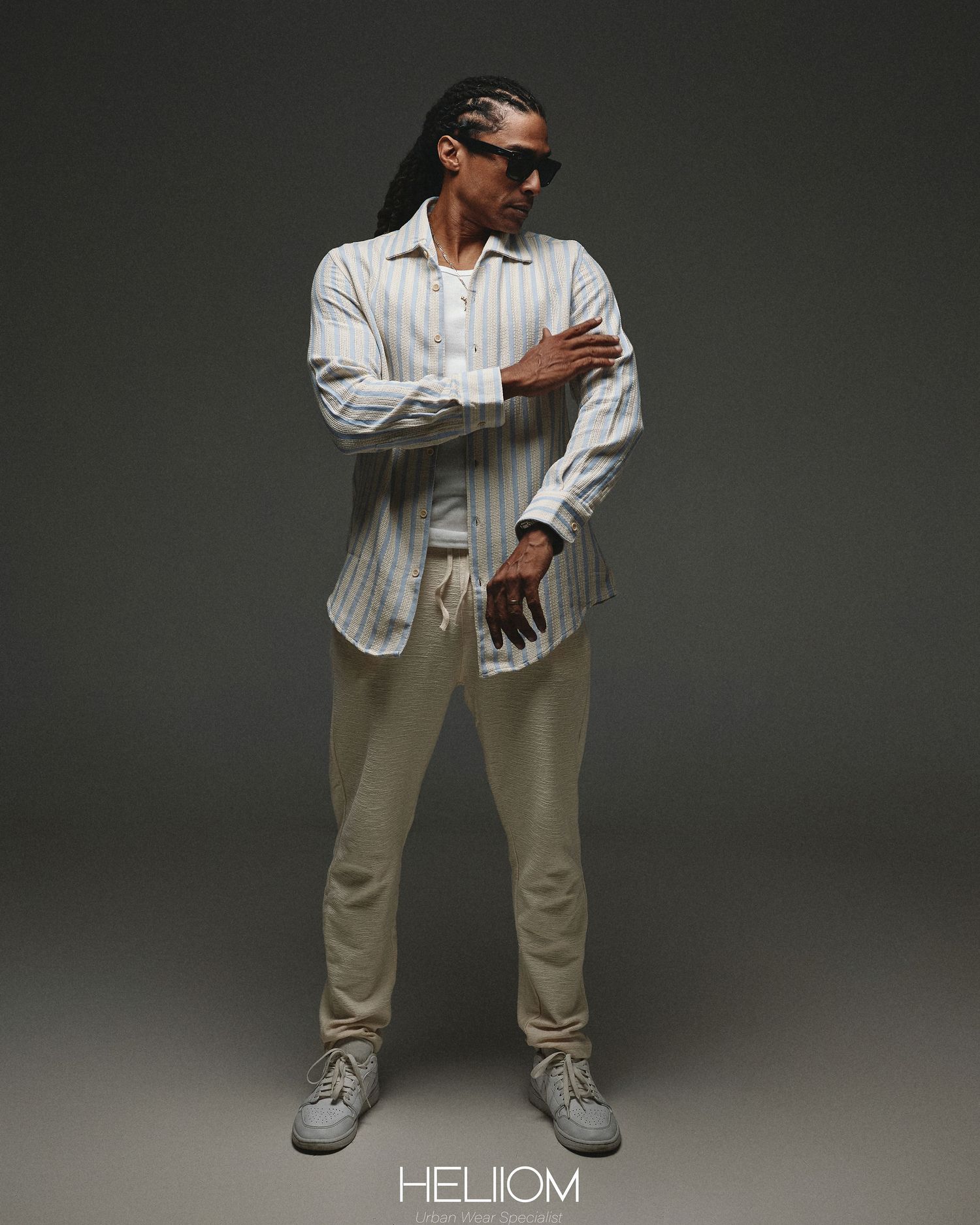 Person in white striped shirt and khaki pants strikes dynamic poses against dark background.