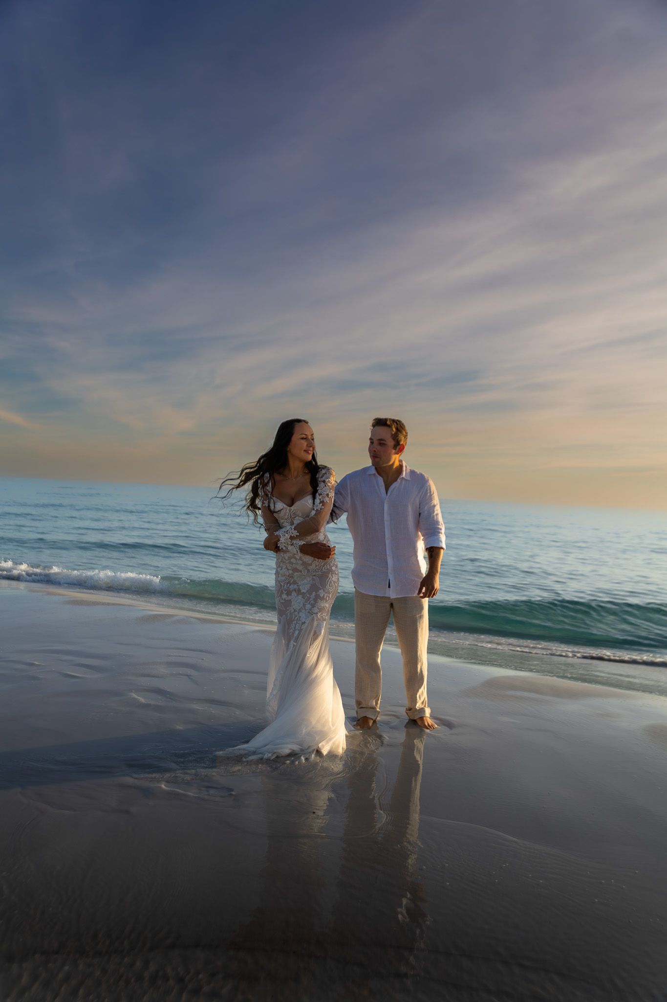 Engagement portraits under the St. Augustine Beach pier, dramatic light by Kaylin Ross Photography