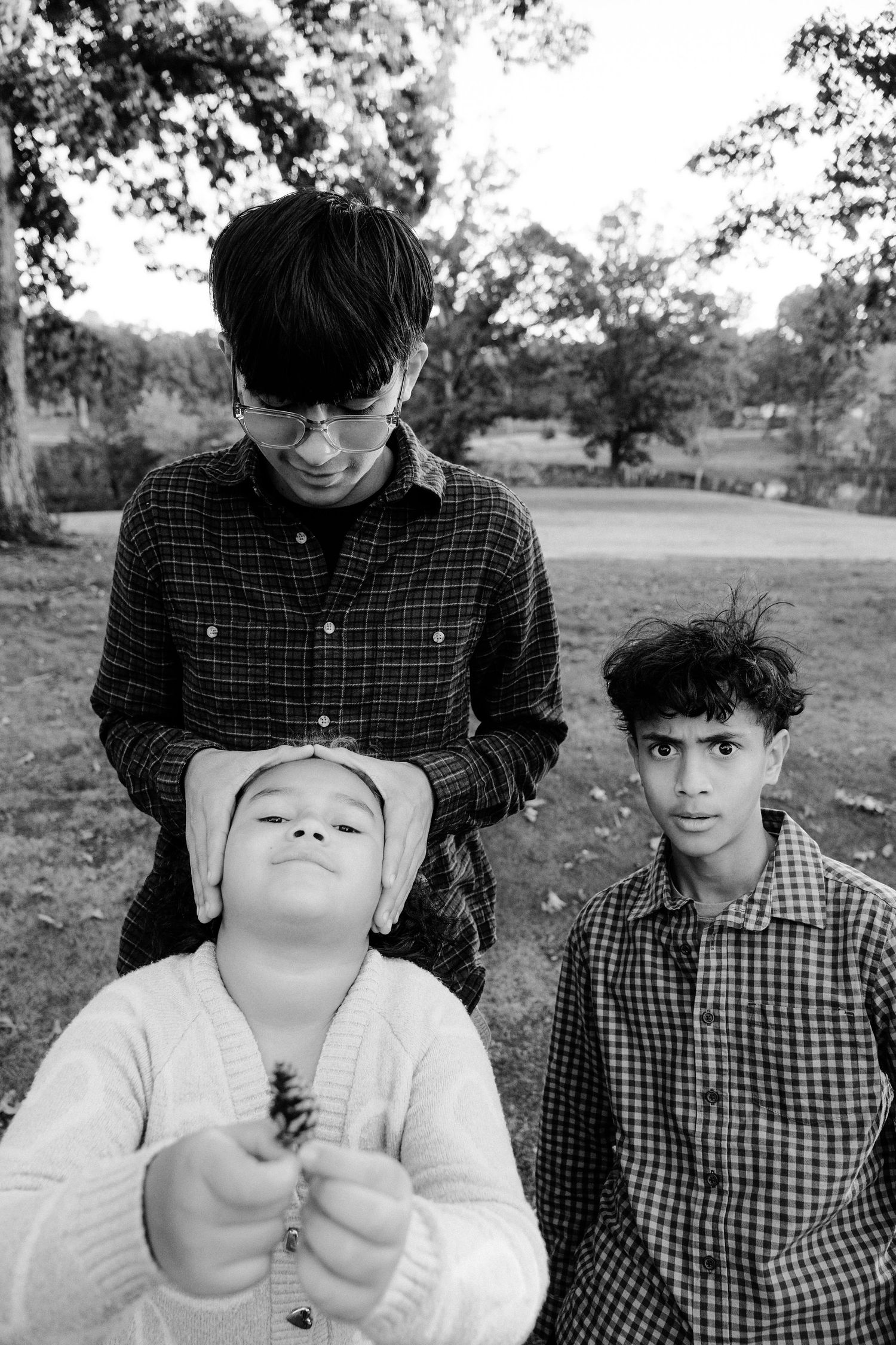 A black and white photo series shows playful expressions and poses in an outdoor setting.