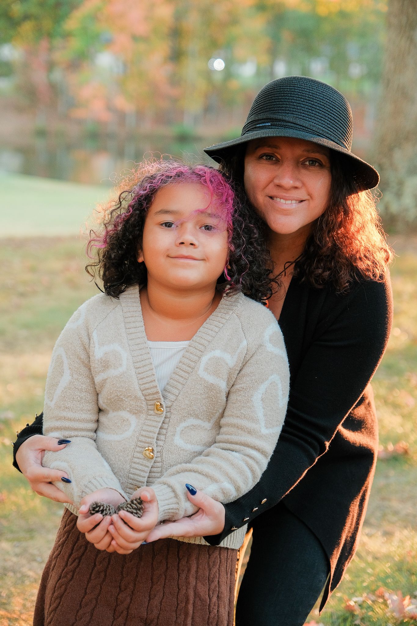 Candid outdoor portraits showing someone holding pine cones against an autumn backdrop.