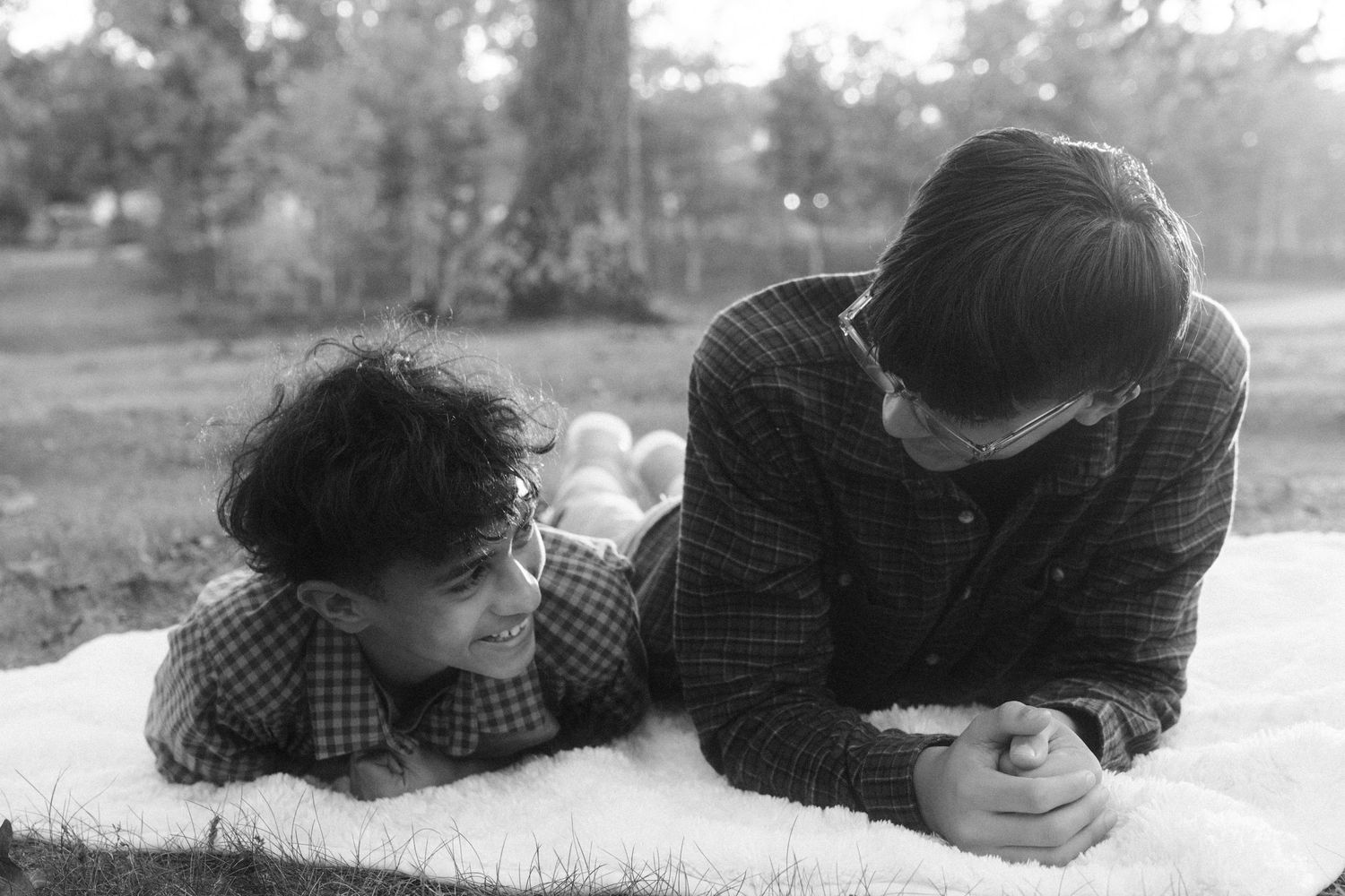 A sequence of black and white film stills showing people lying in grass and looking at each other.