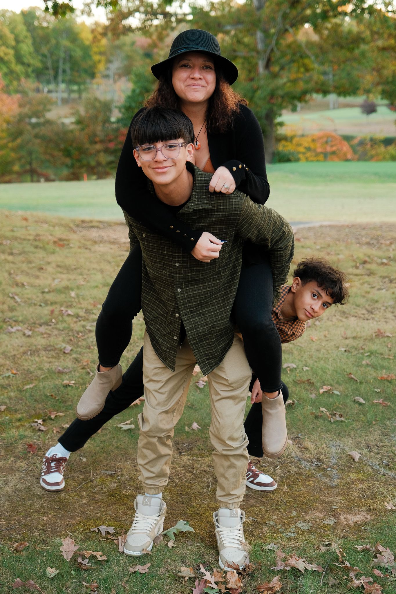 Playful piggyback poses captured in a series of autumn outdoor photos.