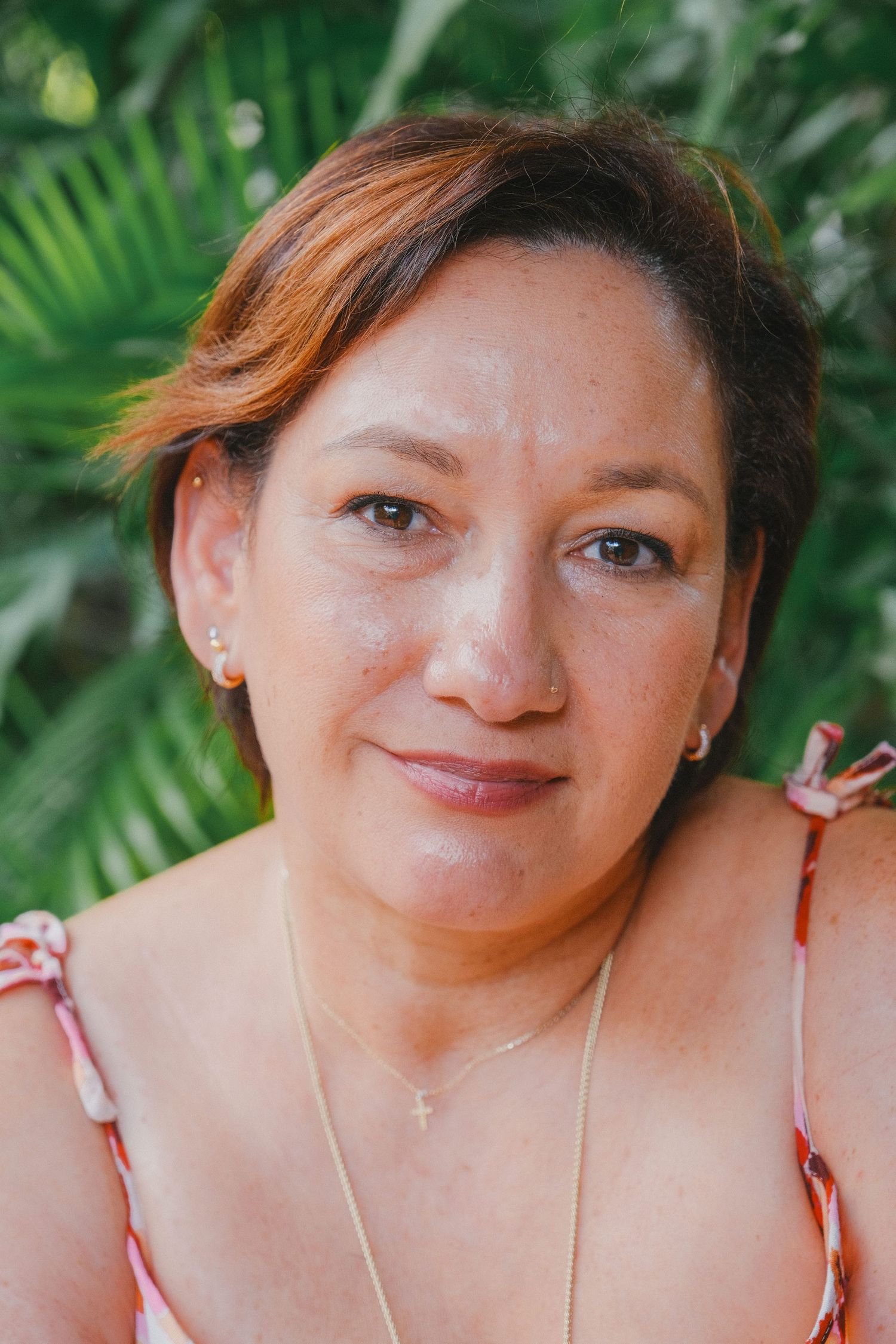 Portrait series showing a person with short dark hair against a green palm leaf background.