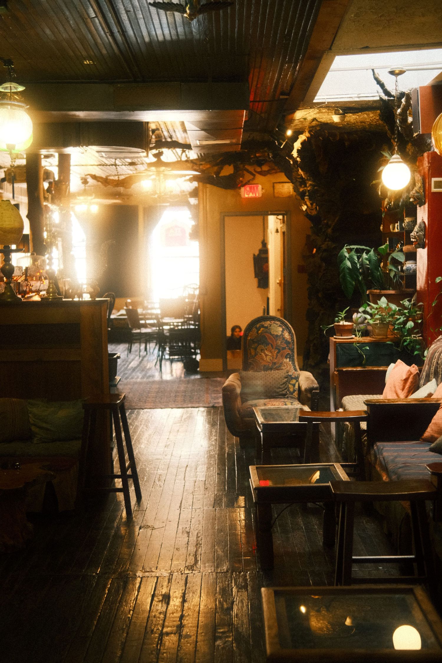 Dimly lit rustic bar interior with wooden floors and warm ambient lighting creating a cozy atmosphere.
