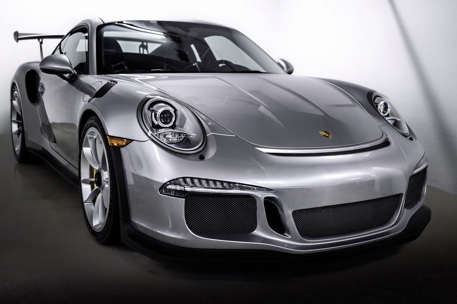 Silver Porsche 911 GT3 RS sports car photographed in a studio setting.