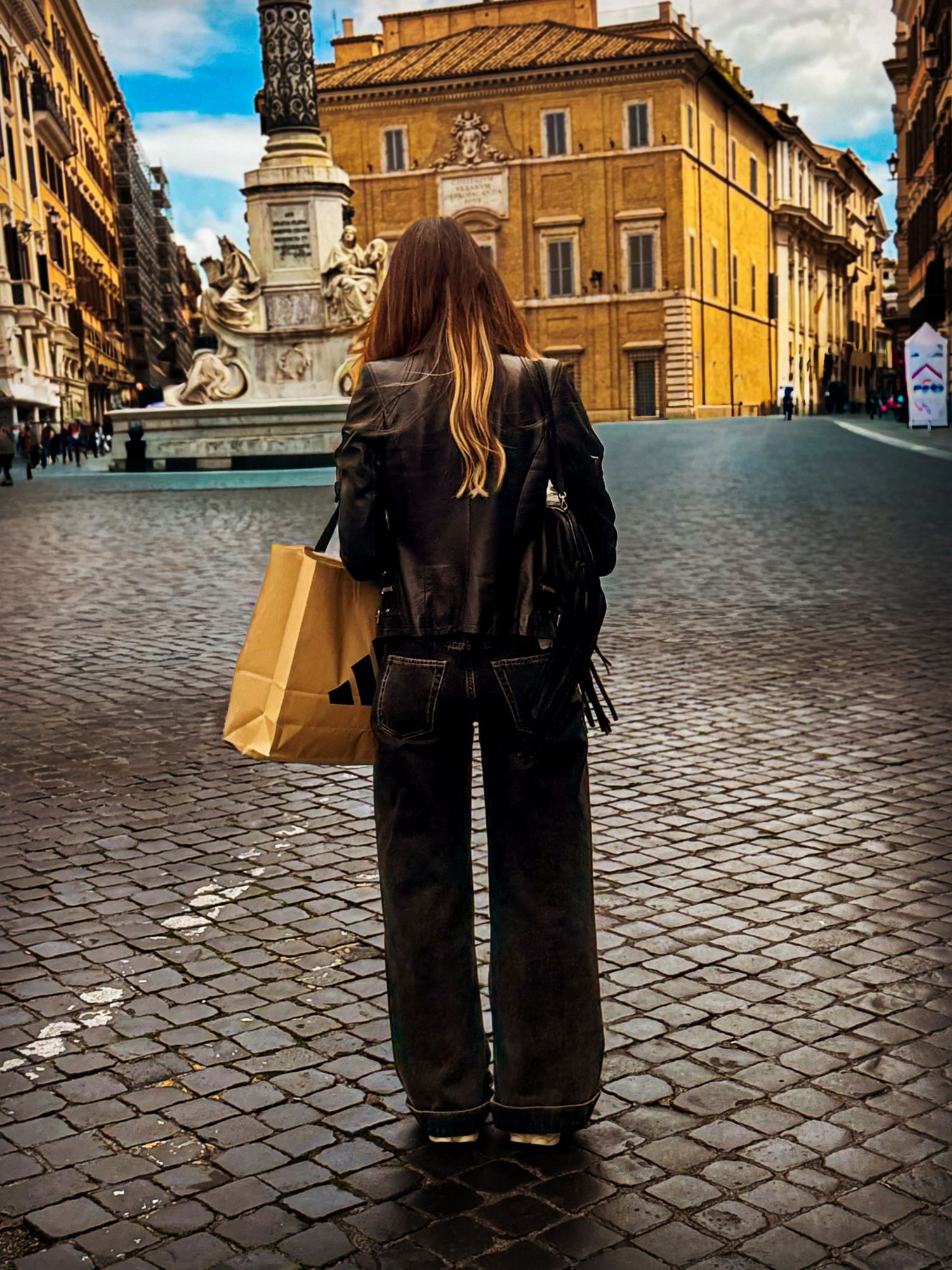 Woman in black leather jacket holding shopping bag on cobblestone piazza in Rome, Italy.