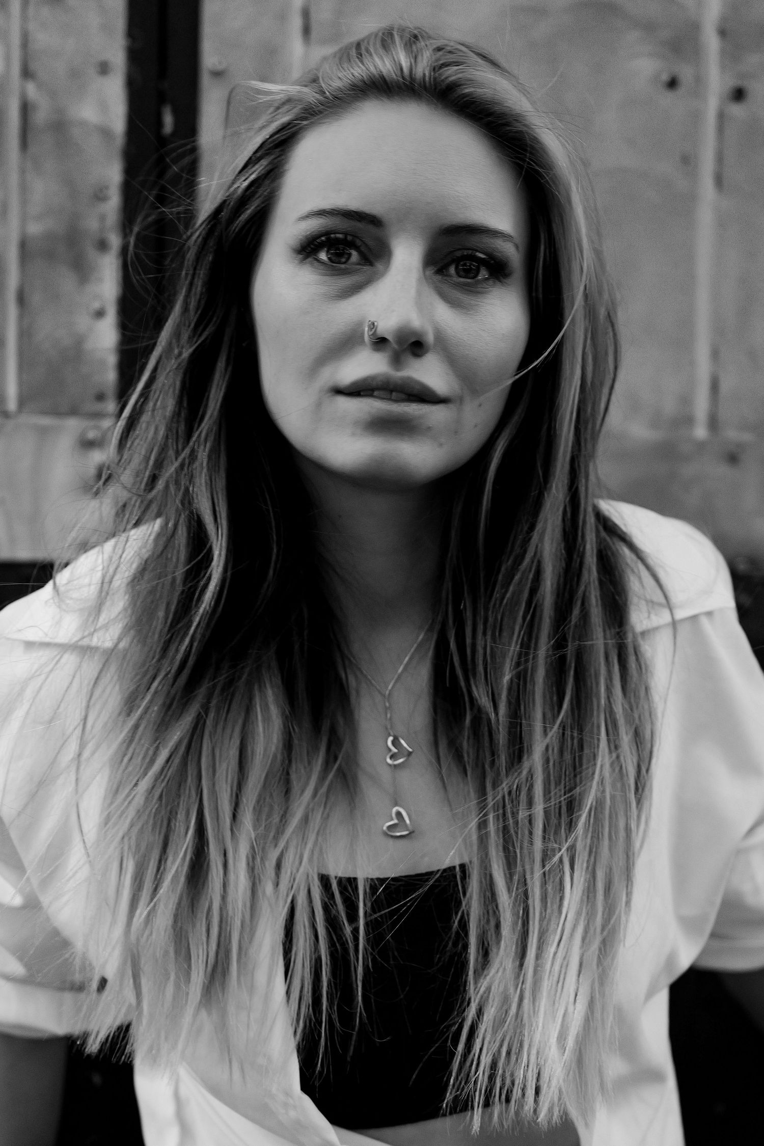 Black and white portrait series showing different angles and expressions in a casual white top.
