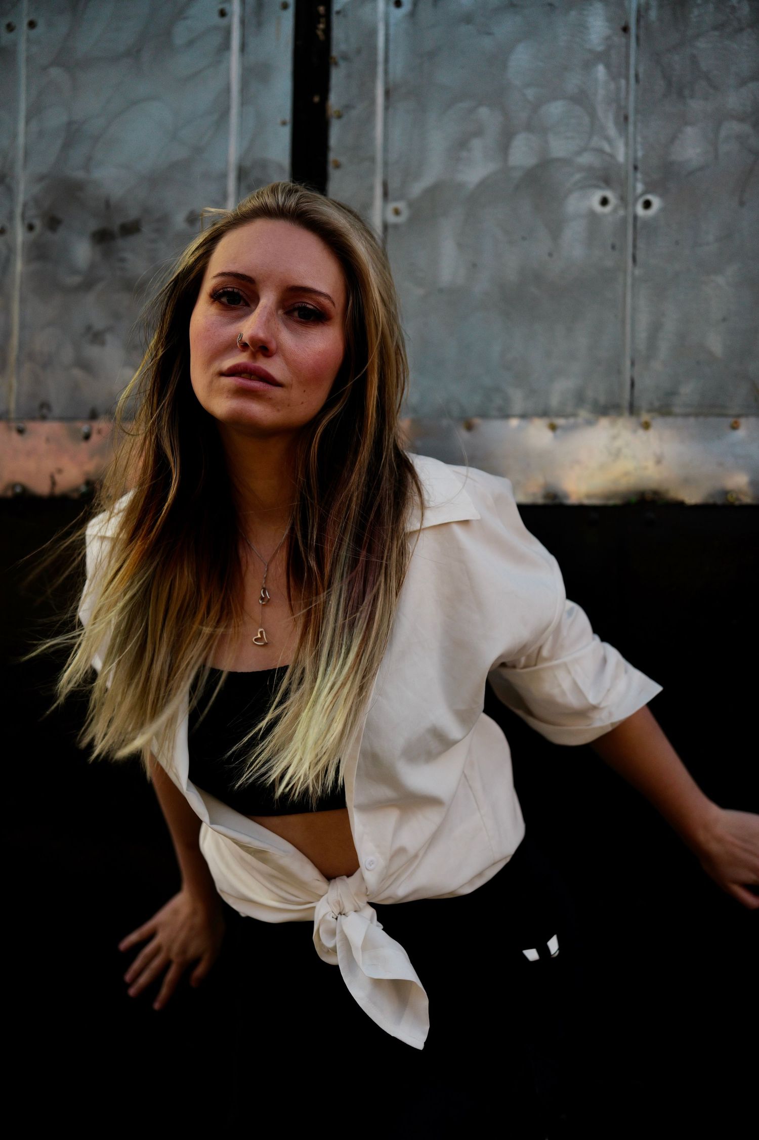 A series of moody portrait photos showing a person in a white button-up shirt against a dark background.