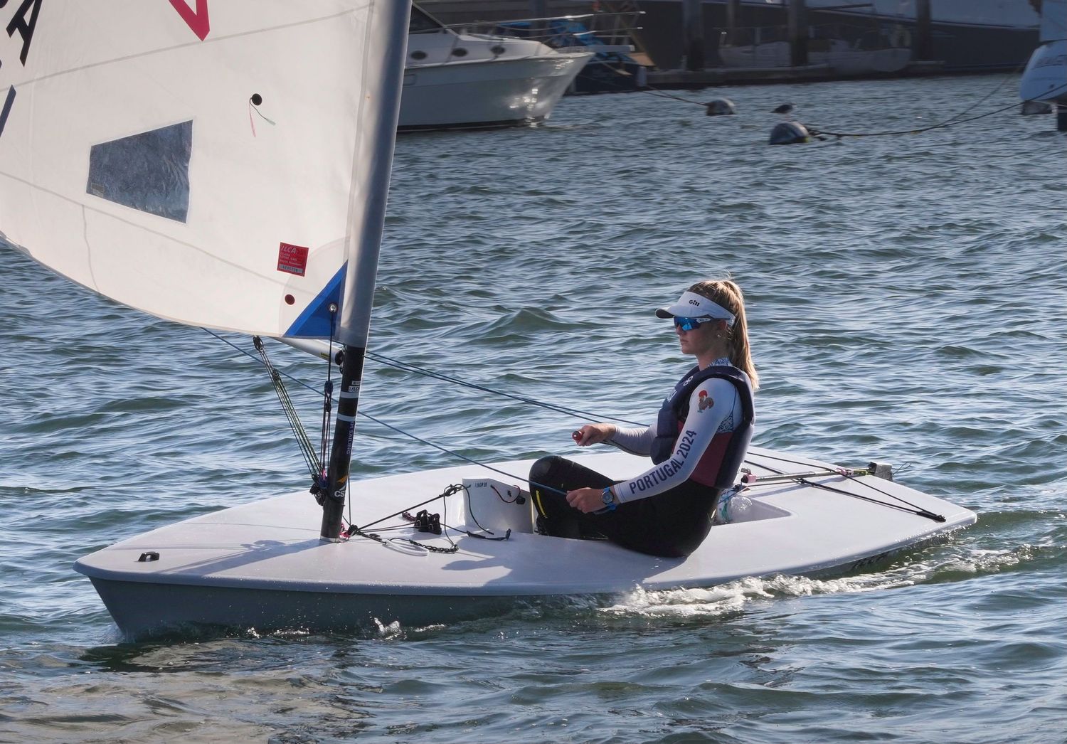Small sailboats racing across blue waters during competitive regatta.