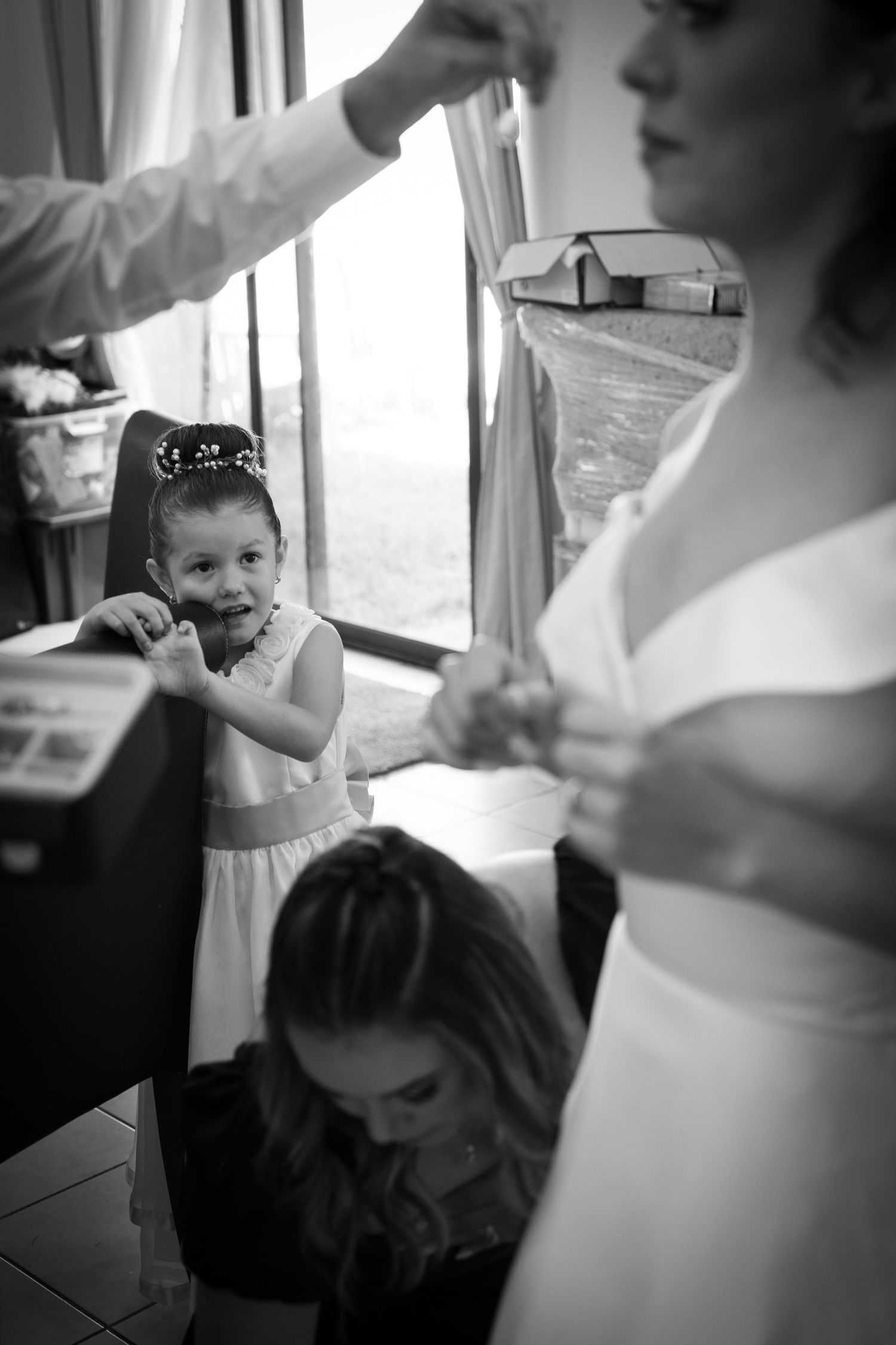 Preparación de novia en blanco y negro con dama y niña, momentos espontáneos /Black and white bride getting ready with bridesmaid and flower