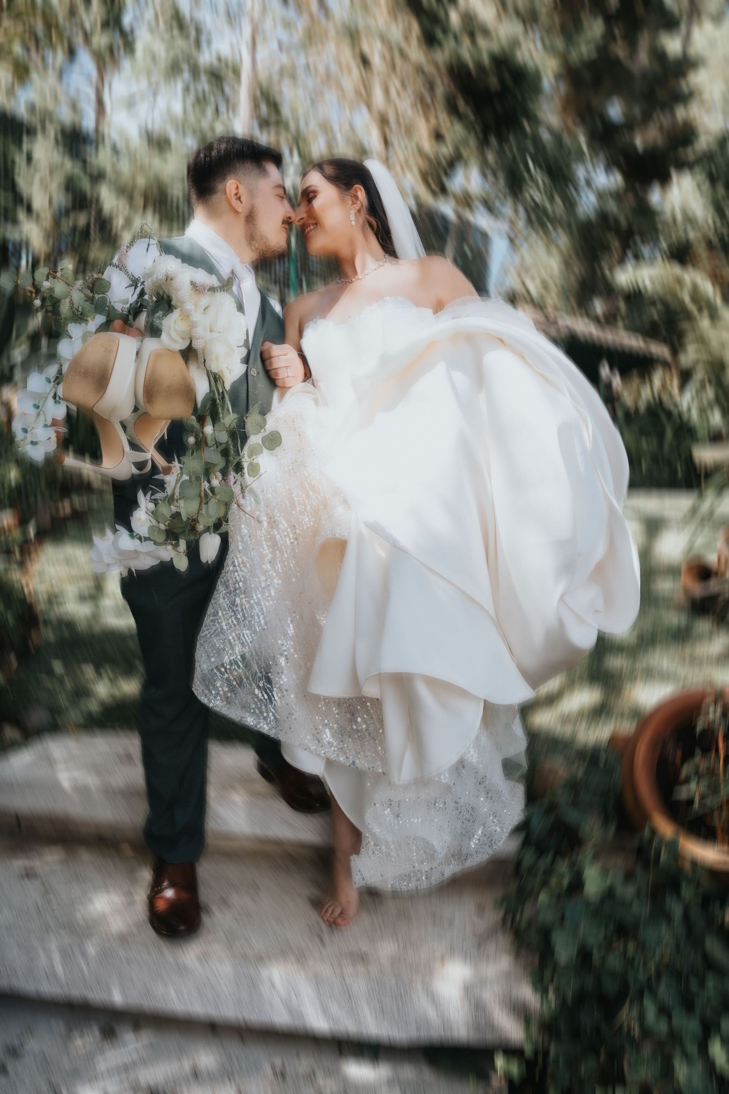 Novios abrazados en escaleras al aire libre con traje y vestido amplio, fotografía documental de bodas/ Bride and groom embracing on outdoor
