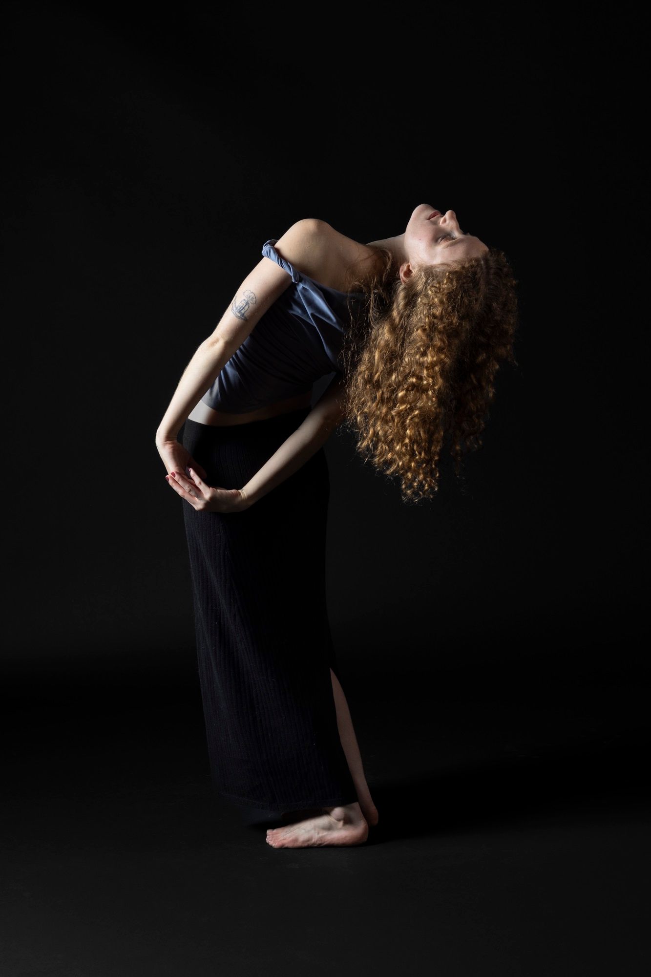 Professional contemporary dance photography. Dynamic movement and sculptural posing with dramatic studio lighting. Premium dancer imagery.