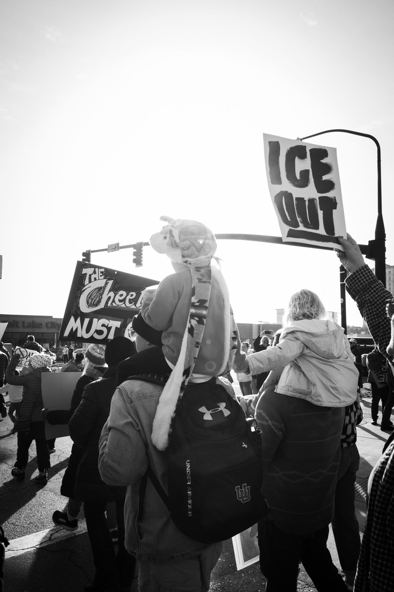 Powerful B&W documentary photography of a family at a city protest. High-contrast urban activism for news and editorial storytelling.
