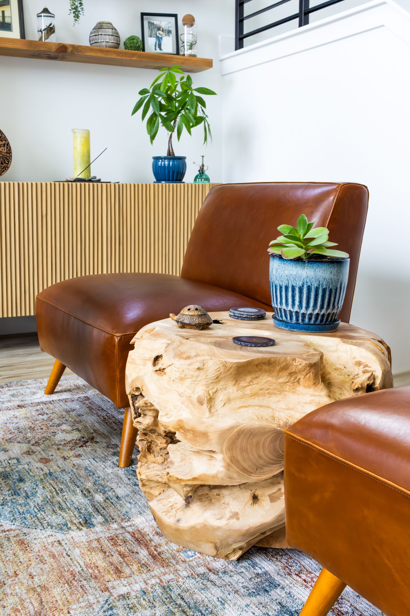 Luxury interior photography of a leather accent chair and live-edge wood table, highlighting natural textures and warm and professional