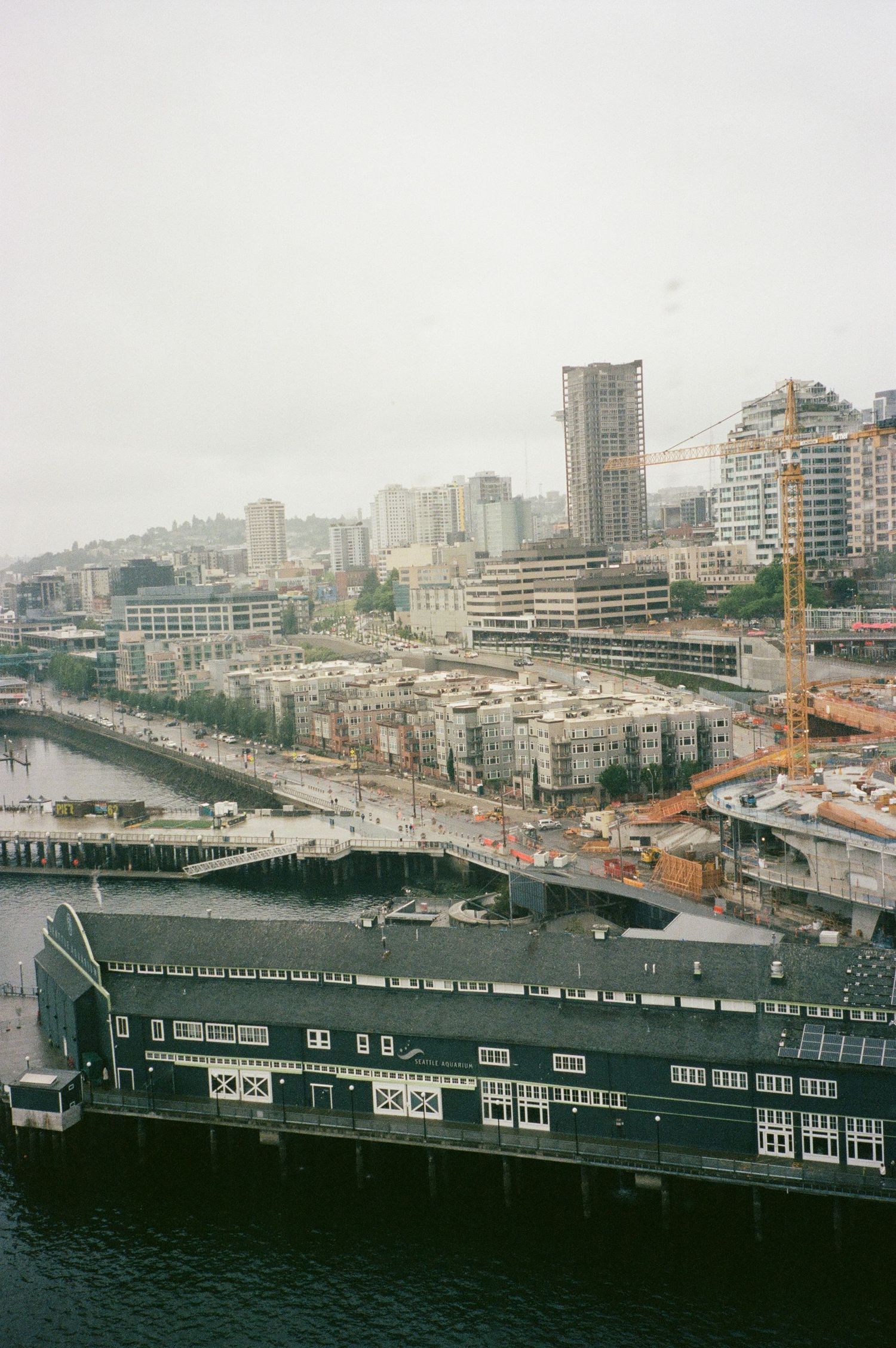High-angle view of the Seattle waterfront and Pike Place Market area. Documentary-style city photography for travel an