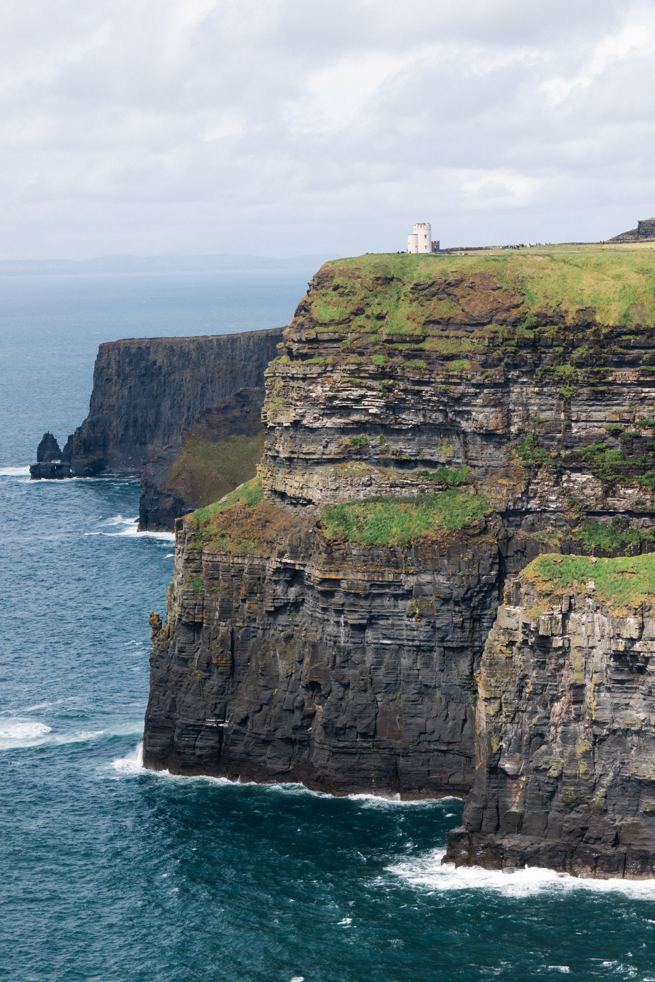 Cliffs of Moher study. Focus on the repetitive, horizontal sedimentary layers and the sharp vertical drop of the limestone. Monumental scale