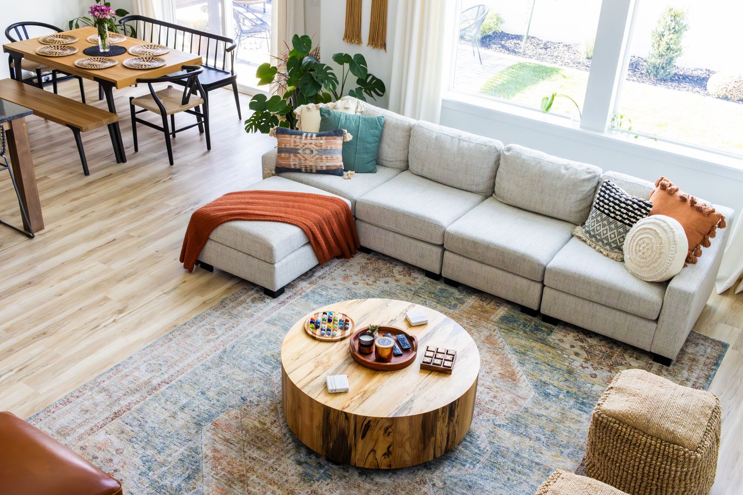 Bright living room interior photography featuring a neutral sectional, textured accents, and a rustic wood coffee table in a modern home.