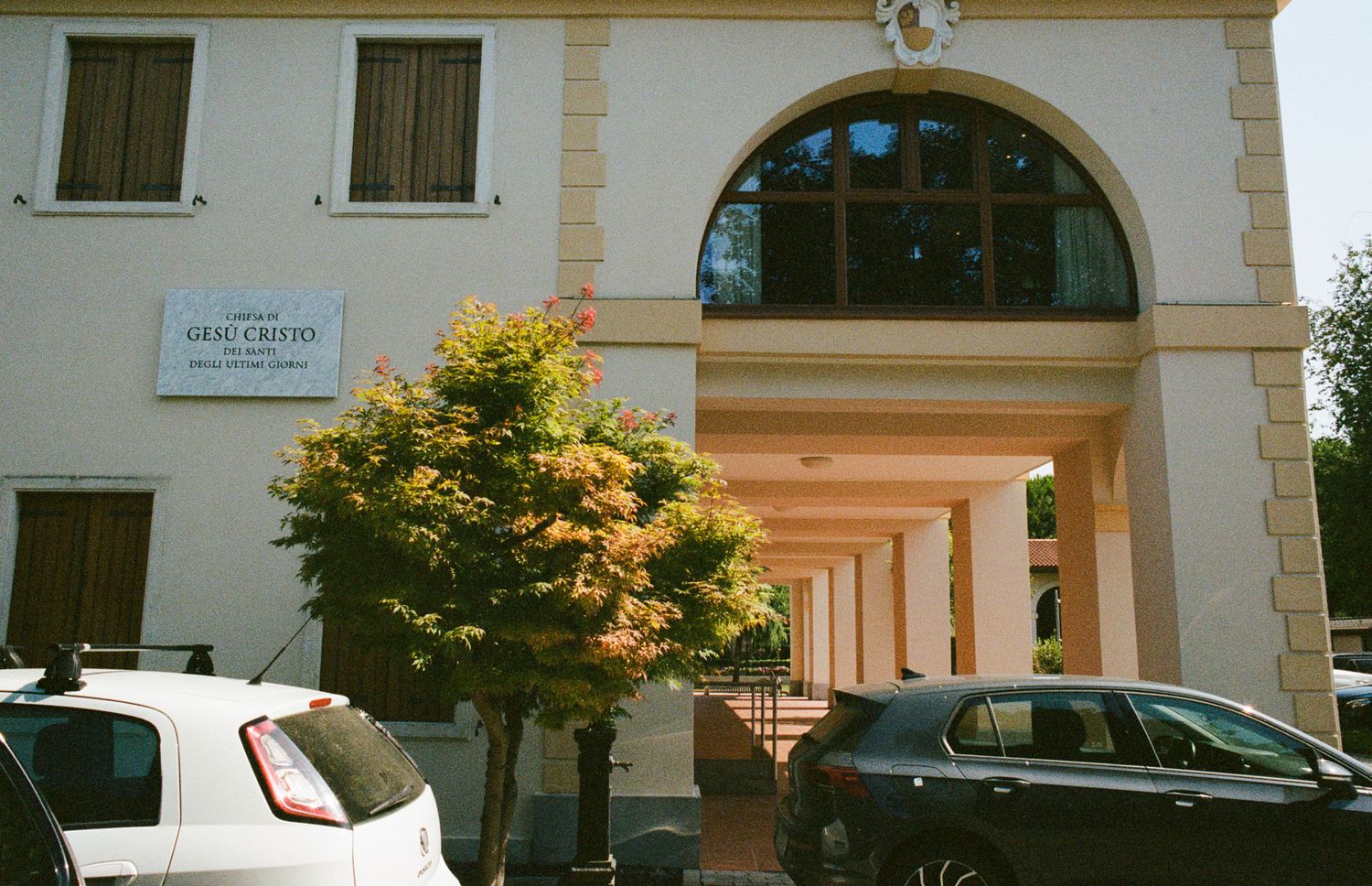Historic Italian villa architecture featuring a grand arched entryway and sunlit portico at the entrance of a classic South Tyrol estate.