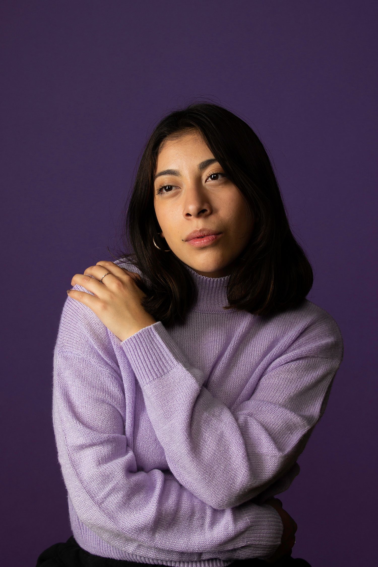 Chic purple-on-purple studio portrait featuring soft textures and intentional posing, perfect for modern fashion and lifestyle branding.