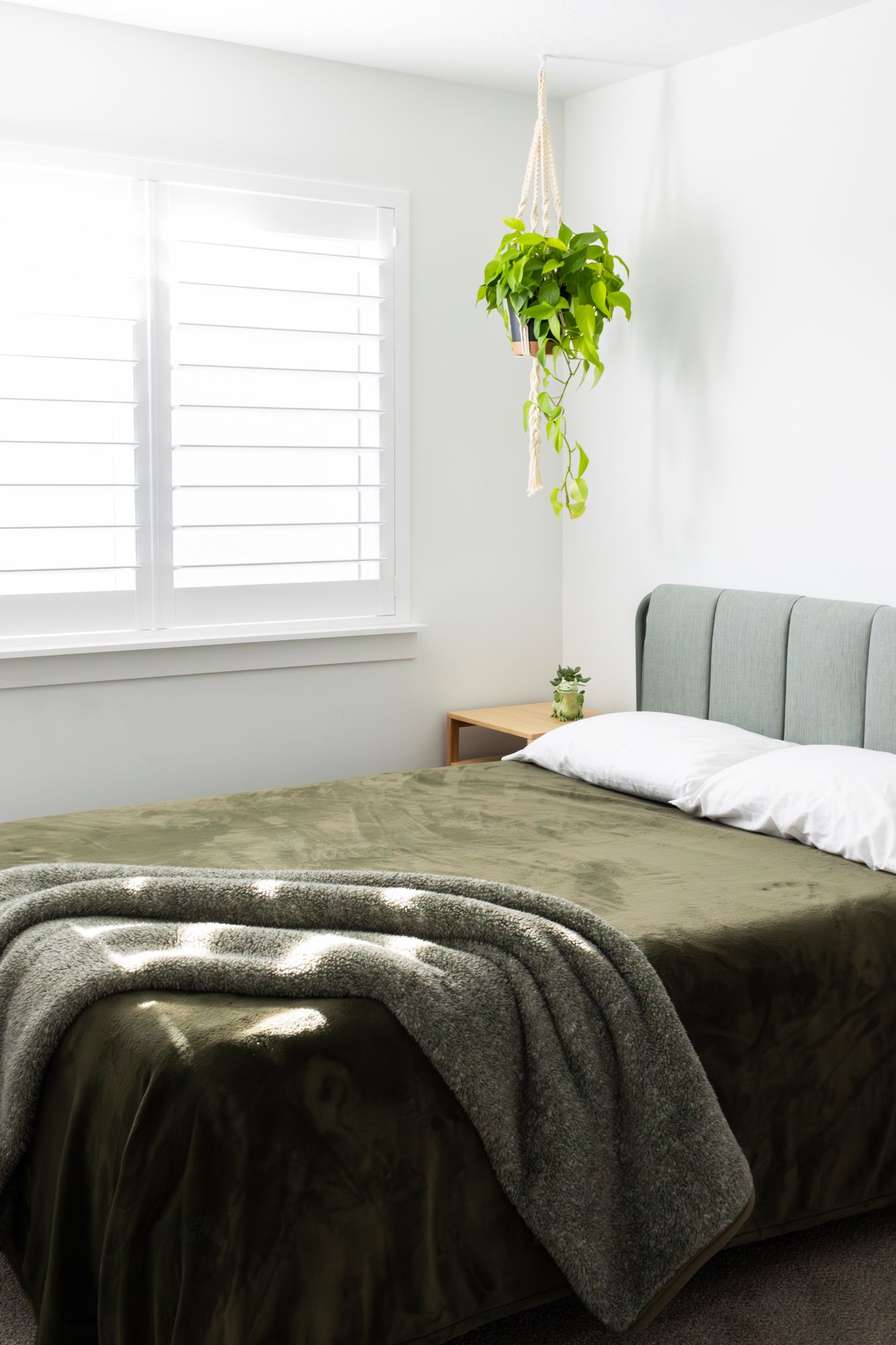 Bright interior photography of a modern bedroom, featuring soft natural light, minimalist decor, and lush greenery for a serene home