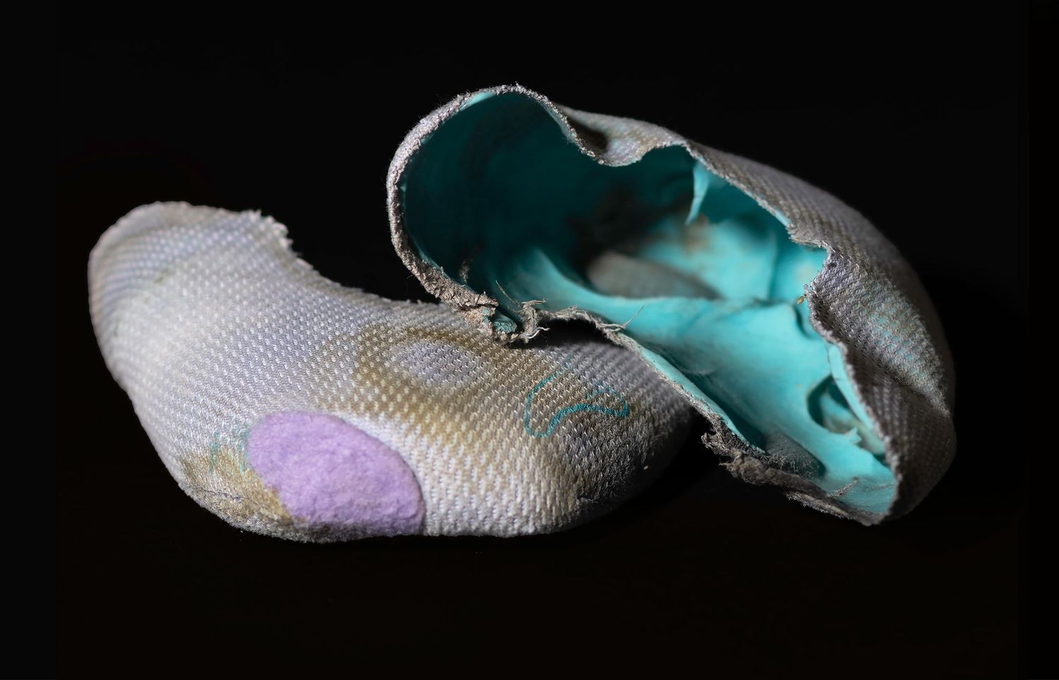 Technical footwear detail. Capturing the lived-in reality of professional gymnastic slippers to emphasize athlete dedication.