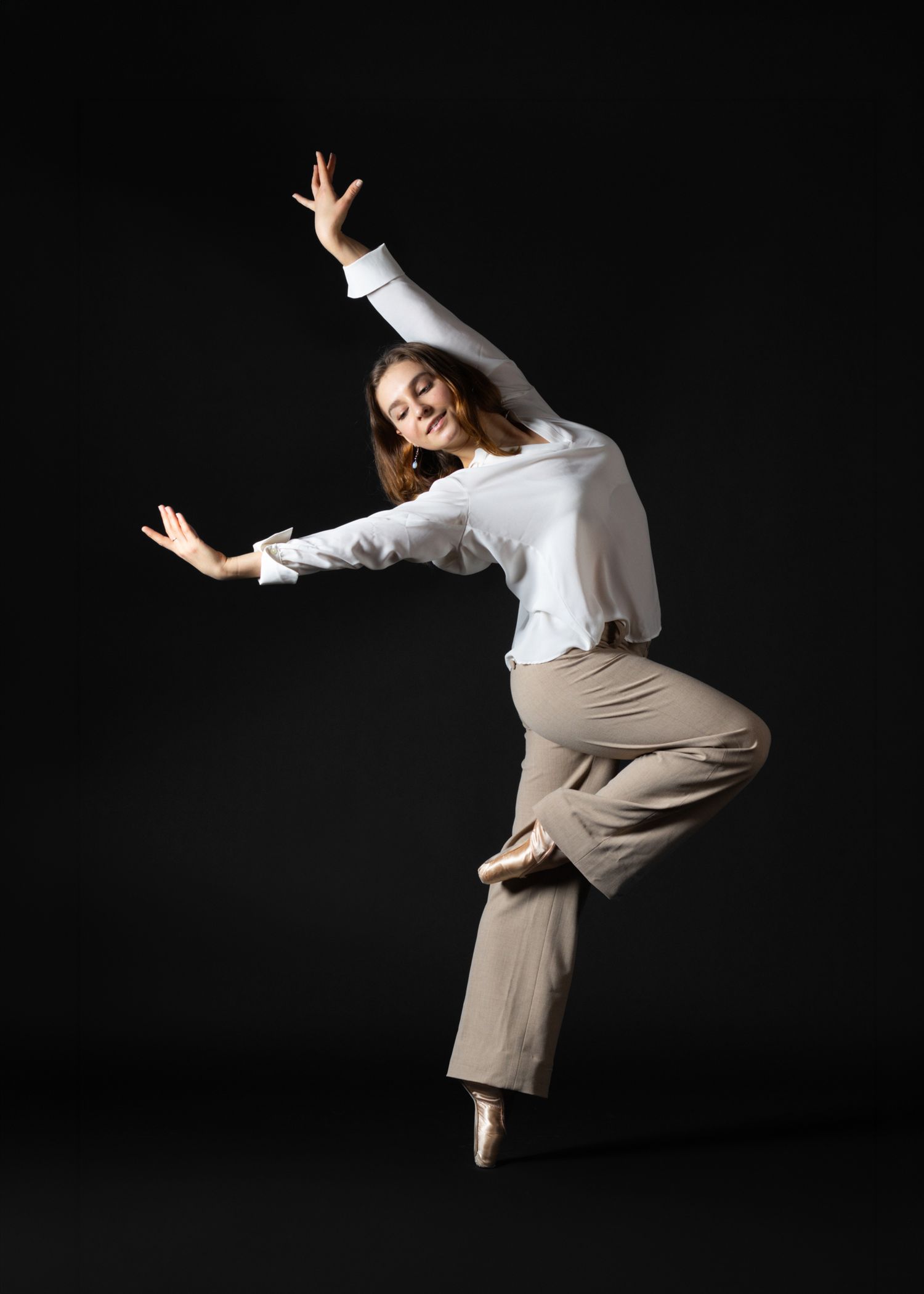 Dynamic contemporary dance photography. Ballerina in pointe shoes and modern attire on black. High-quality imagery for dance portfolios.