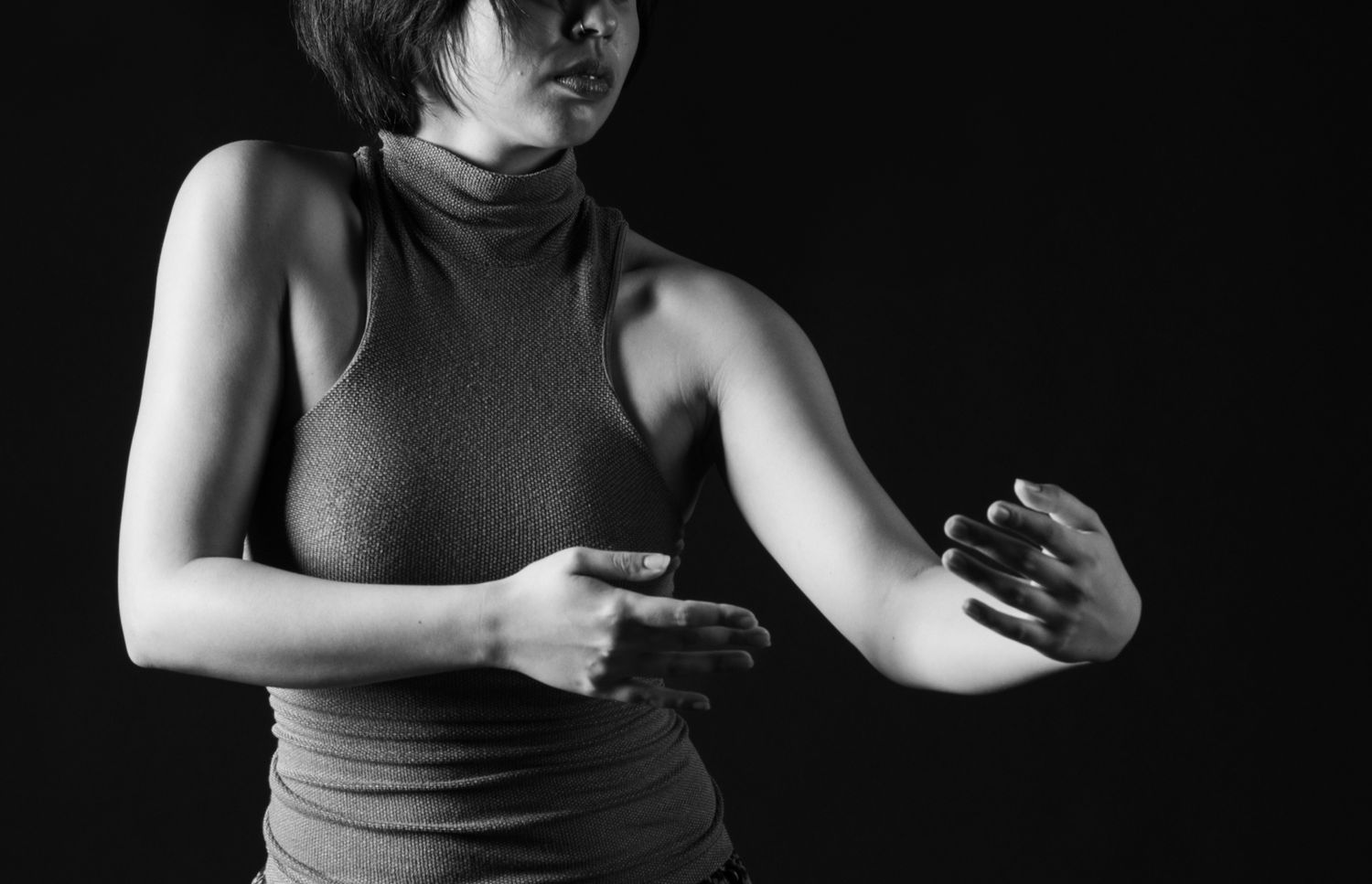 Shadow and light in motion. An intimate, low-key portrait capturing the expressive language of hands and the fluid tension of a dancer
