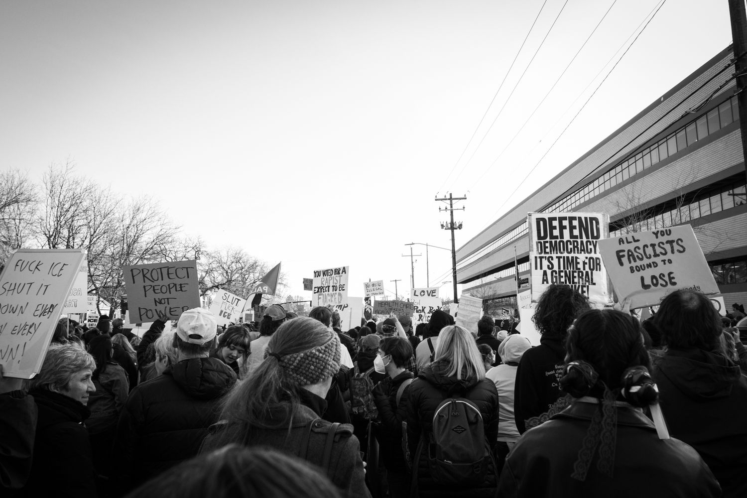 Powerful B&W documentary photography of a large crowd at a city protest. Wide-angle urban activism for news and editorial storytelling.