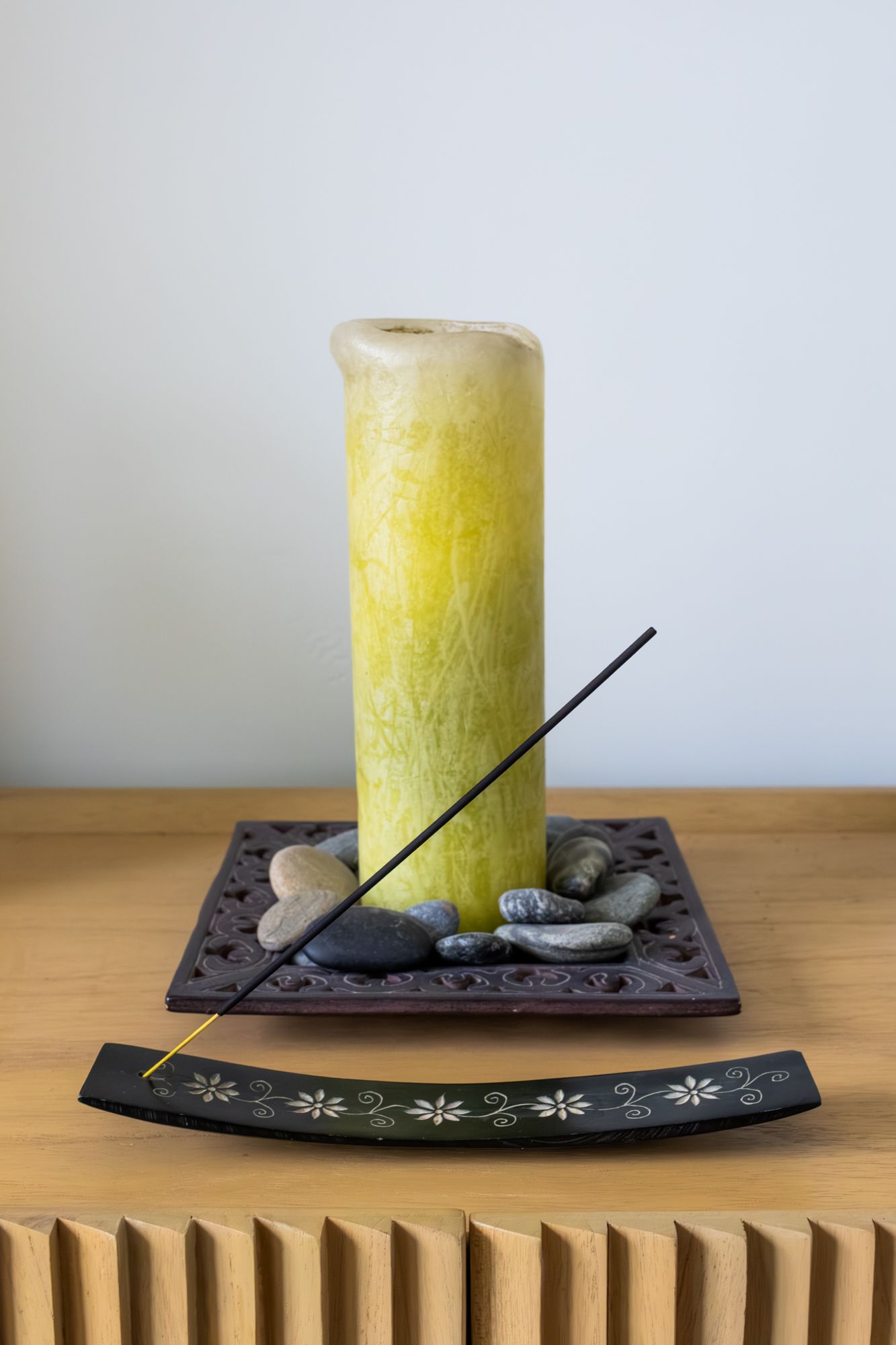 Minimalist wellness still life featuring a candle and incense, utilizing clean composition and natural light for spa and home decor branding