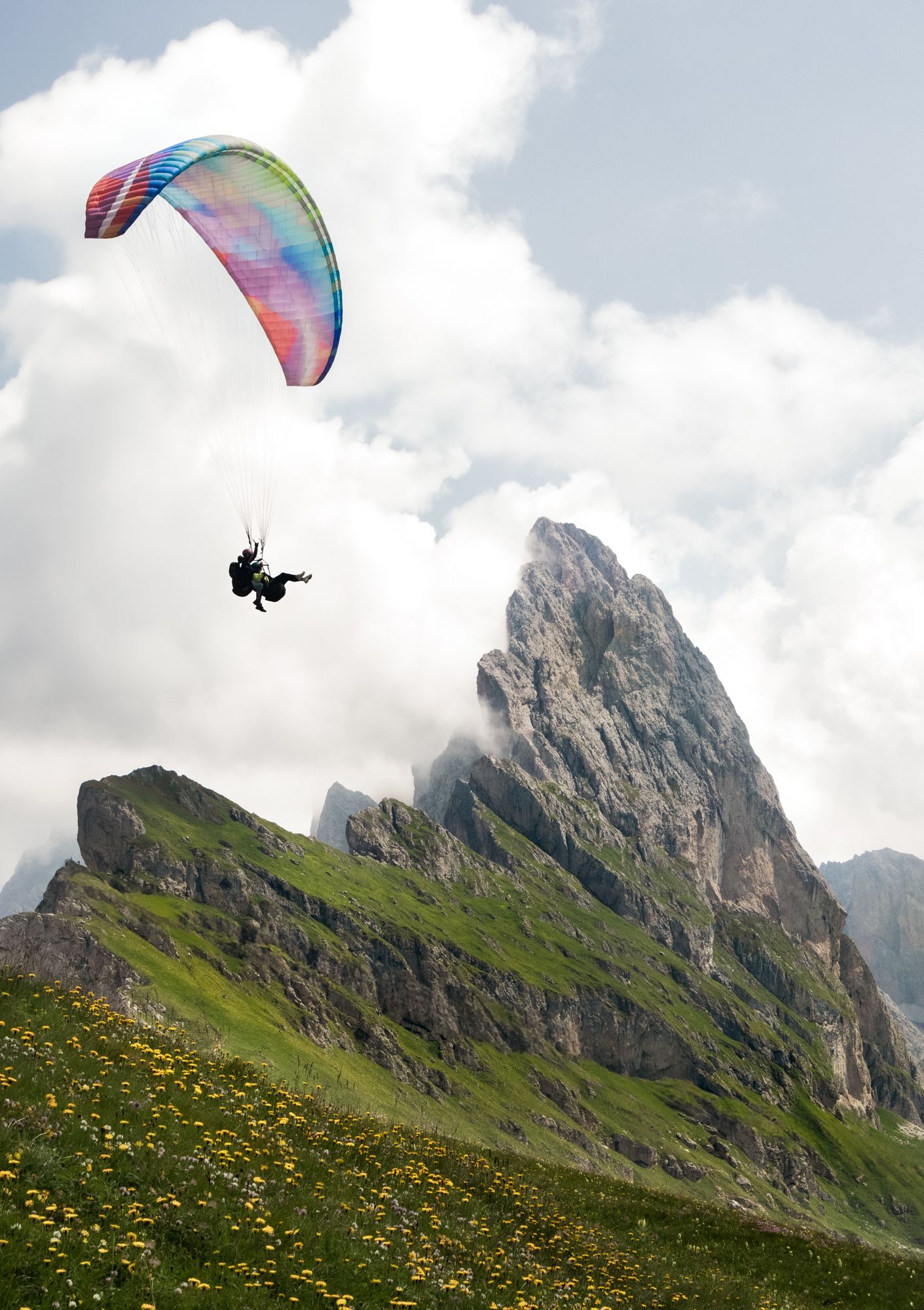 Soar over the jagged peaks of Seceda as a colorful paraglider drifts above the iconic Ridgeline in the heart of Italy's Val Gardena.