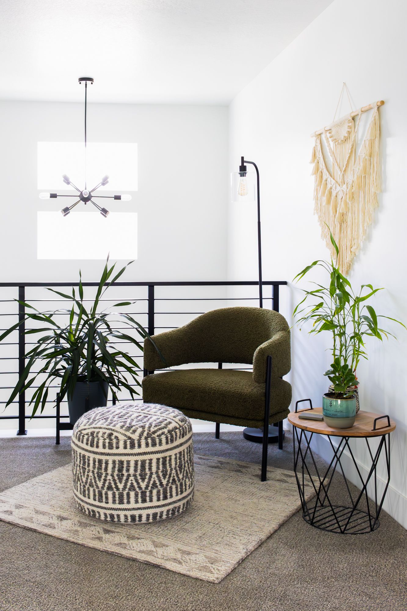 Contemporary interior photography of a styled loft featuring a velvet accent chair, macramé wall art, and bright, airy natural lighting.