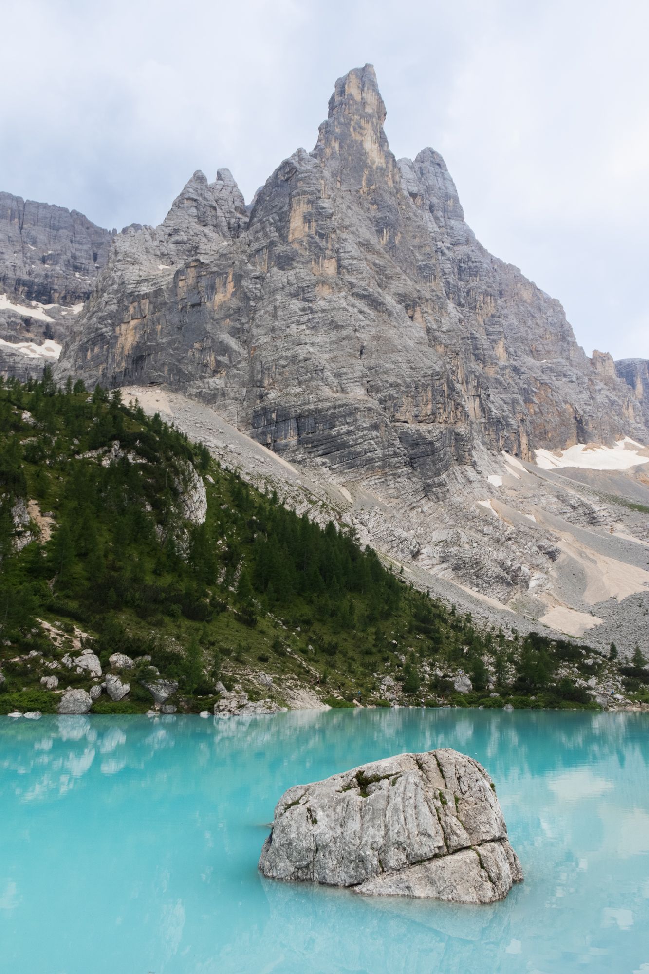 Marvel at the milky turquoise waters of Lago di Sorapis, framed by the rugged limestone peaks of the Sorapiss Group in the Italian Dolomites