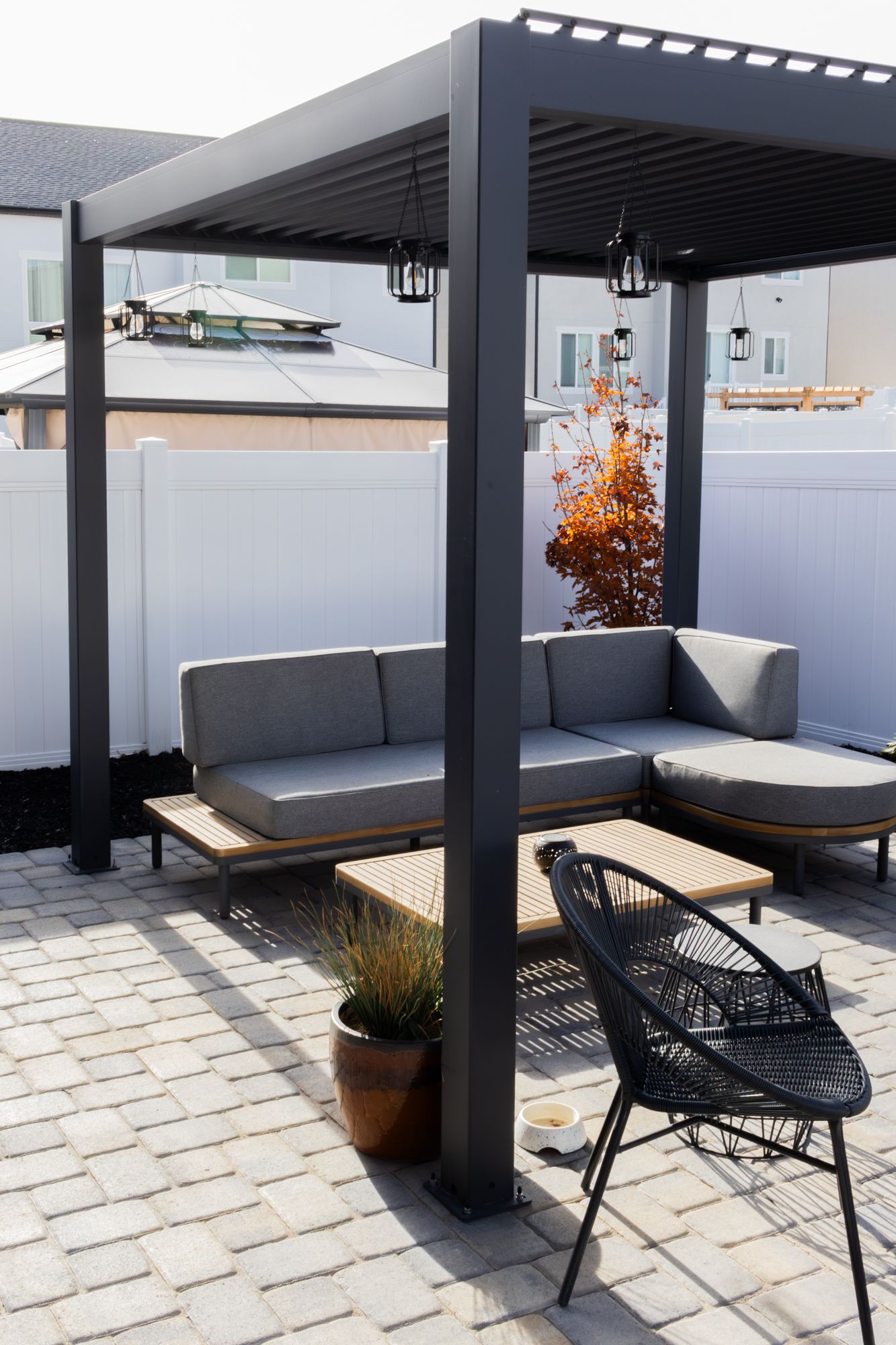 Professional exterior photography of a modern louvered pergola and patio lounge, highlighting clean architectural lines and outdoor living.