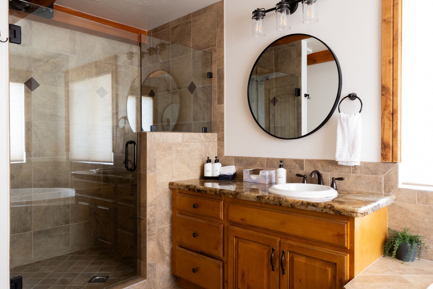 Bright, modern bathroom interior with rustic wood accents. Clean architectural photography for hospitality and home lifestyle brands.