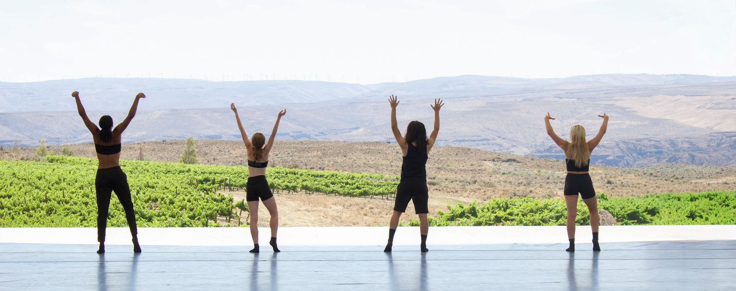 Four dancers celebrate under an open sky, their silhouettes framed by a vast desert horizon. A moment of pure energy, art, and freedom.