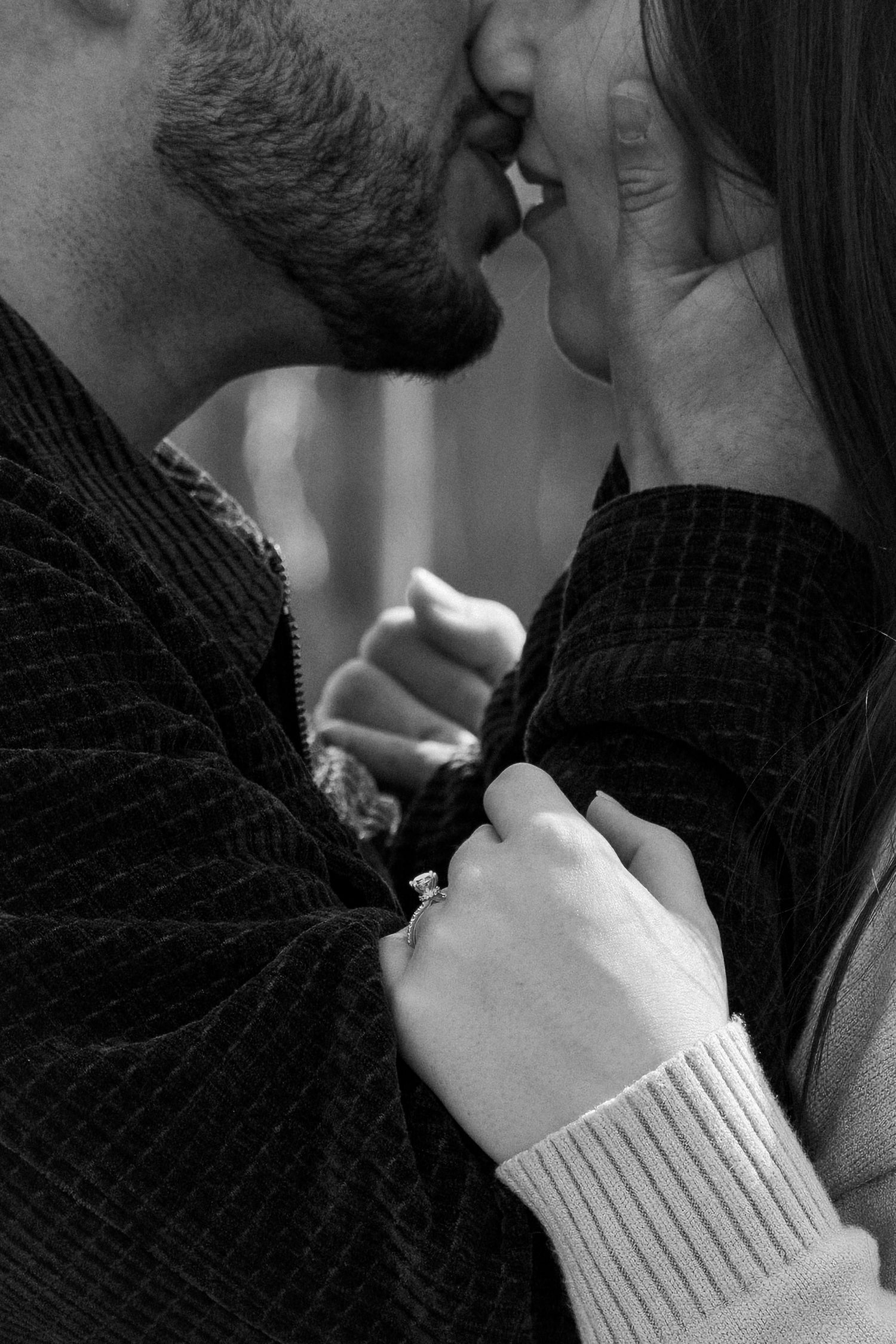 A romantic black and white sequence of two people in an intimate kiss, with one person wearing a white knit sweater.