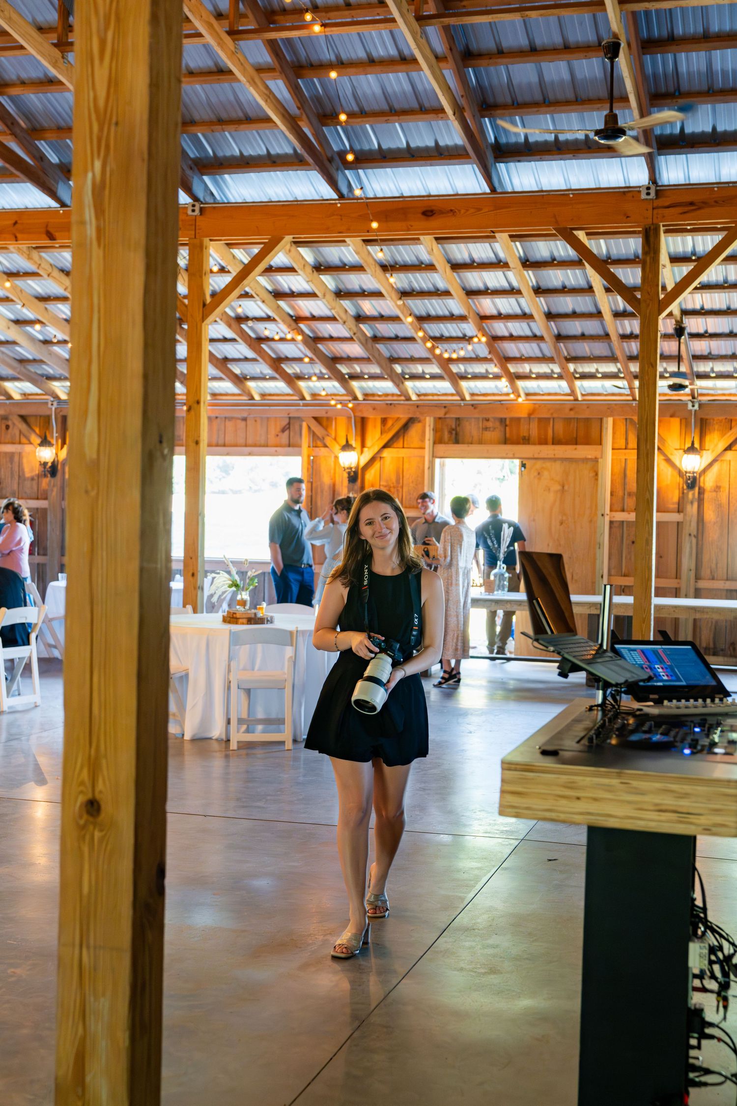 Event venue features exposed wooden beams and rustic design elements during a celebration setup.