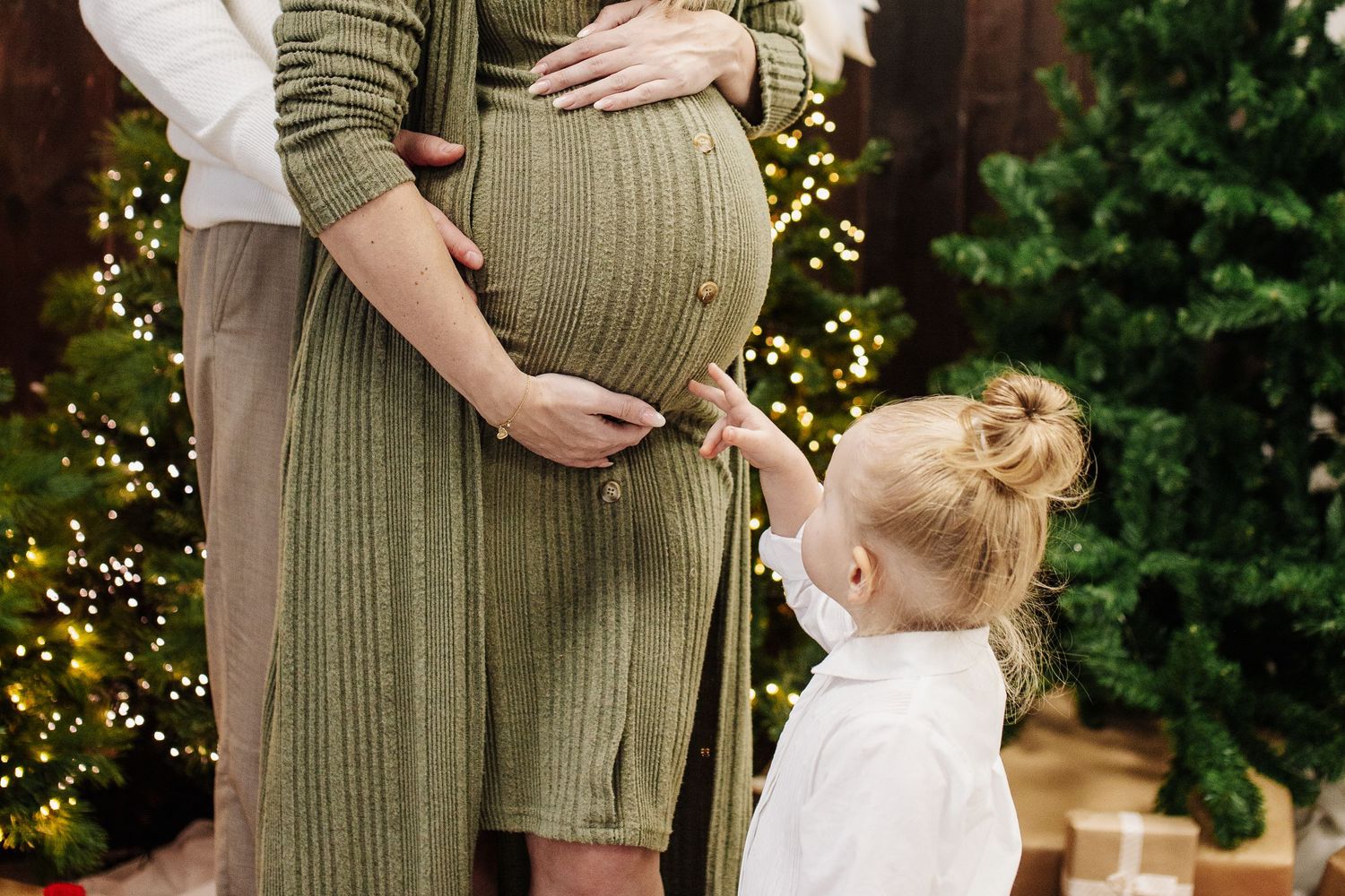 Kleines Mädchen fasst den Schwangerschaftsbauch ihrer Mutter an