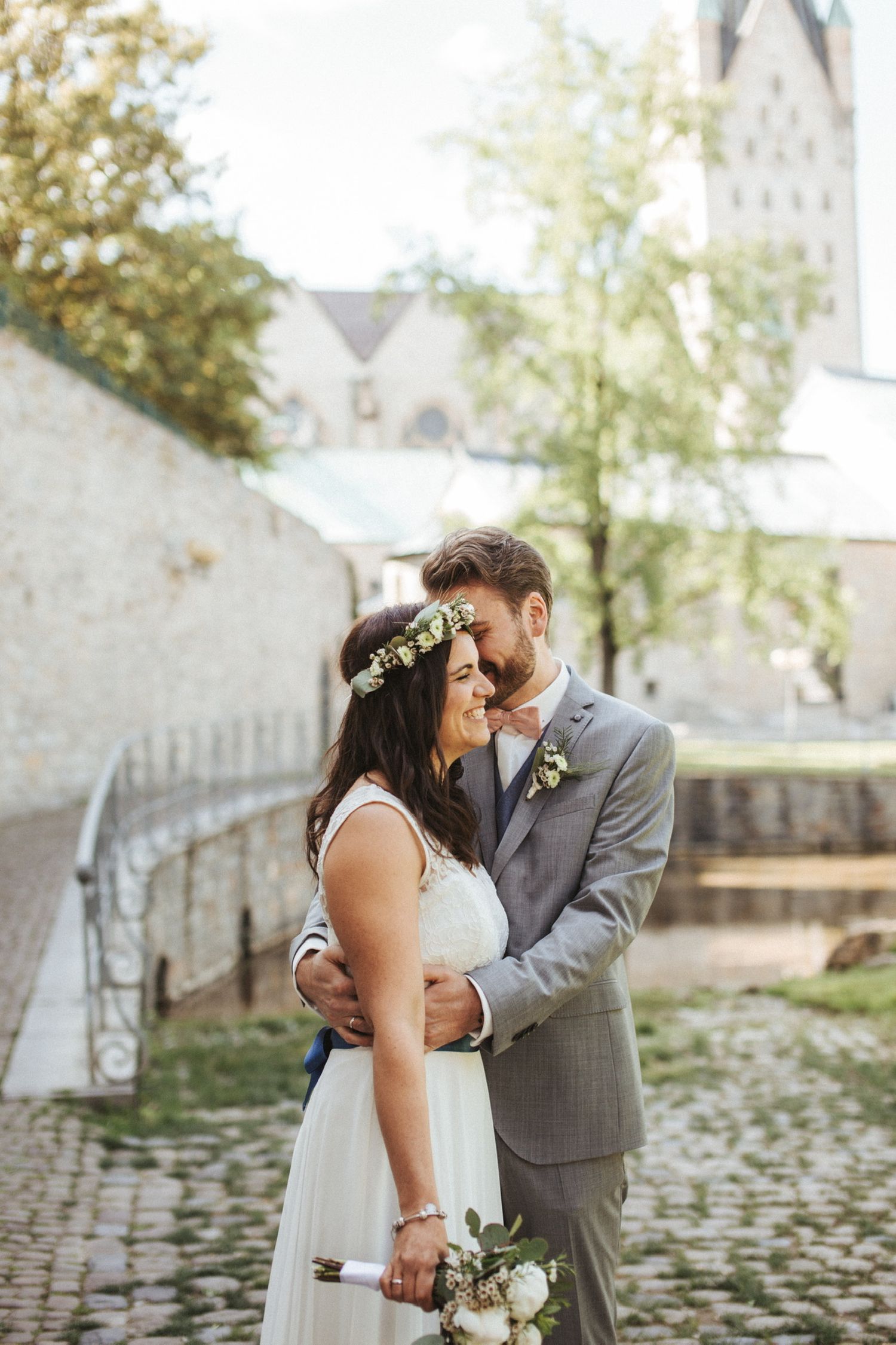 Hochzeitspaar in Paderborn vor dem Dom, Ehemann flüstern Ehefrau etwas ins Ohr