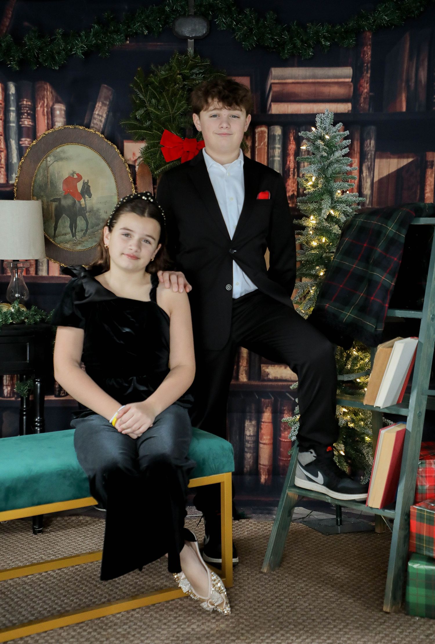Portrait in front of a holiday bookshelf scene with green bench seating and plaid holiday decor.