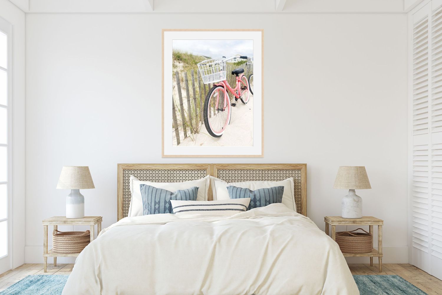 Coastal-style bedroom with white walls and framed pink bicycle art above the bed.