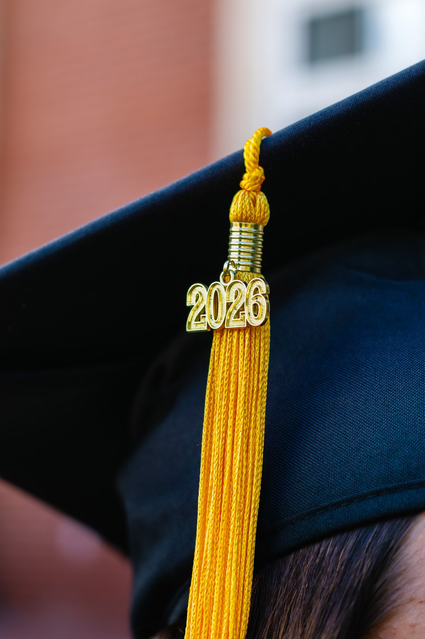 Close-up of a black graduation cap with a gold 2026 tassel charm, symbolizing academic achievement.