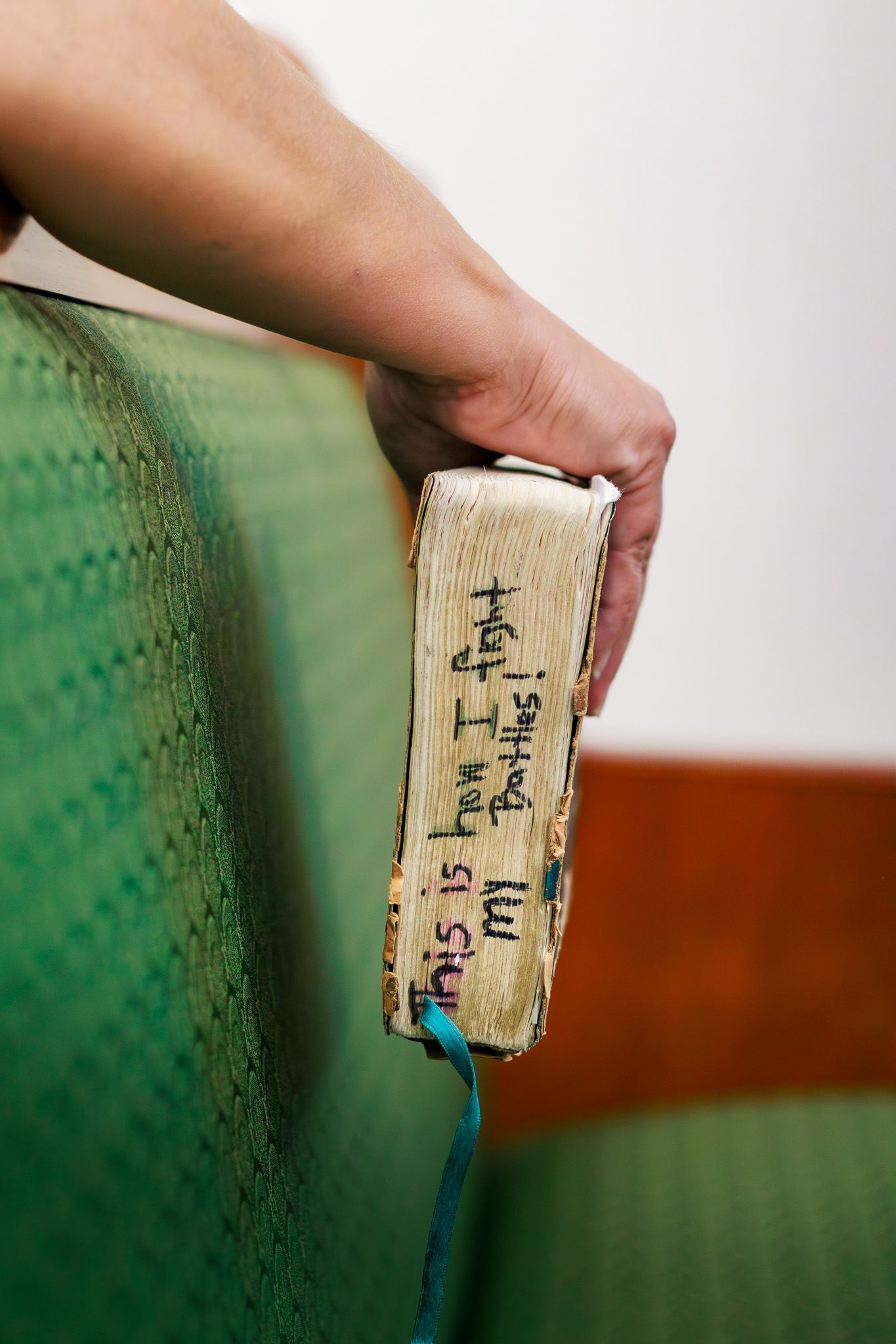 Worn Bible held by hand with inscription reading this is how I fight my battles on the pages.