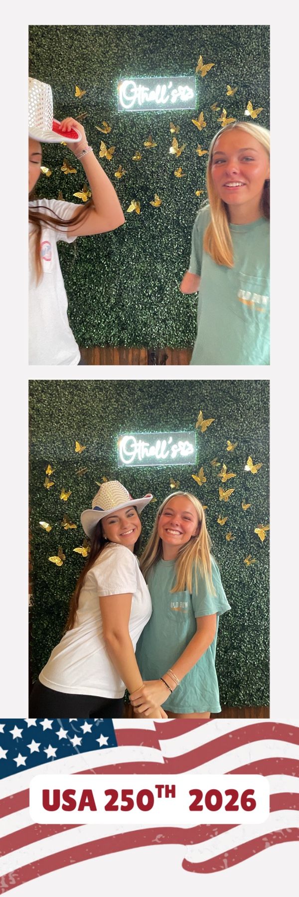 Two smiling young women pose in front of a green hedge wall with gold butterflies and neon sign at a USA 250th 2026 event.