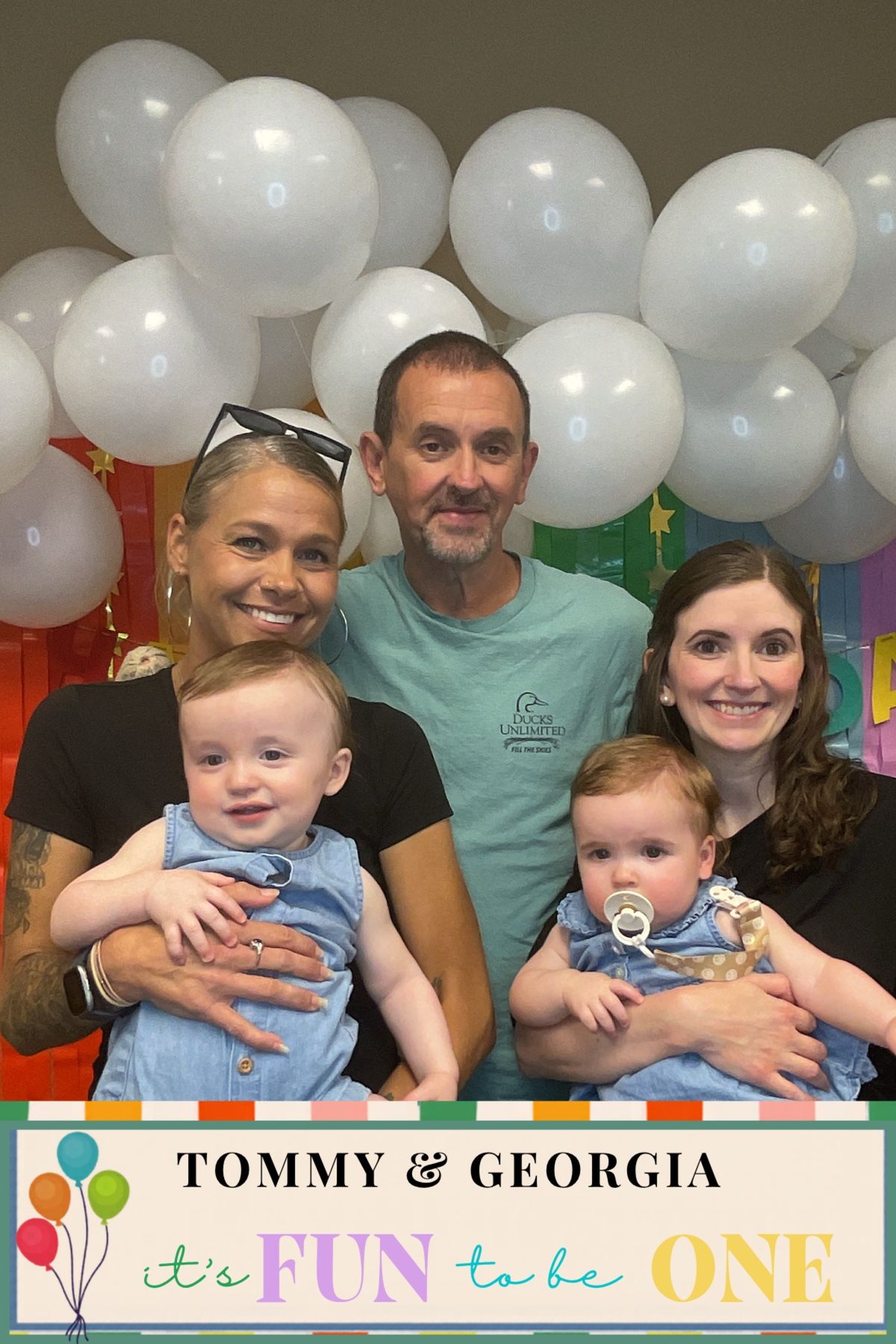 Group of five adults holding twin babies at Tommy & Georgia's first birthday party.