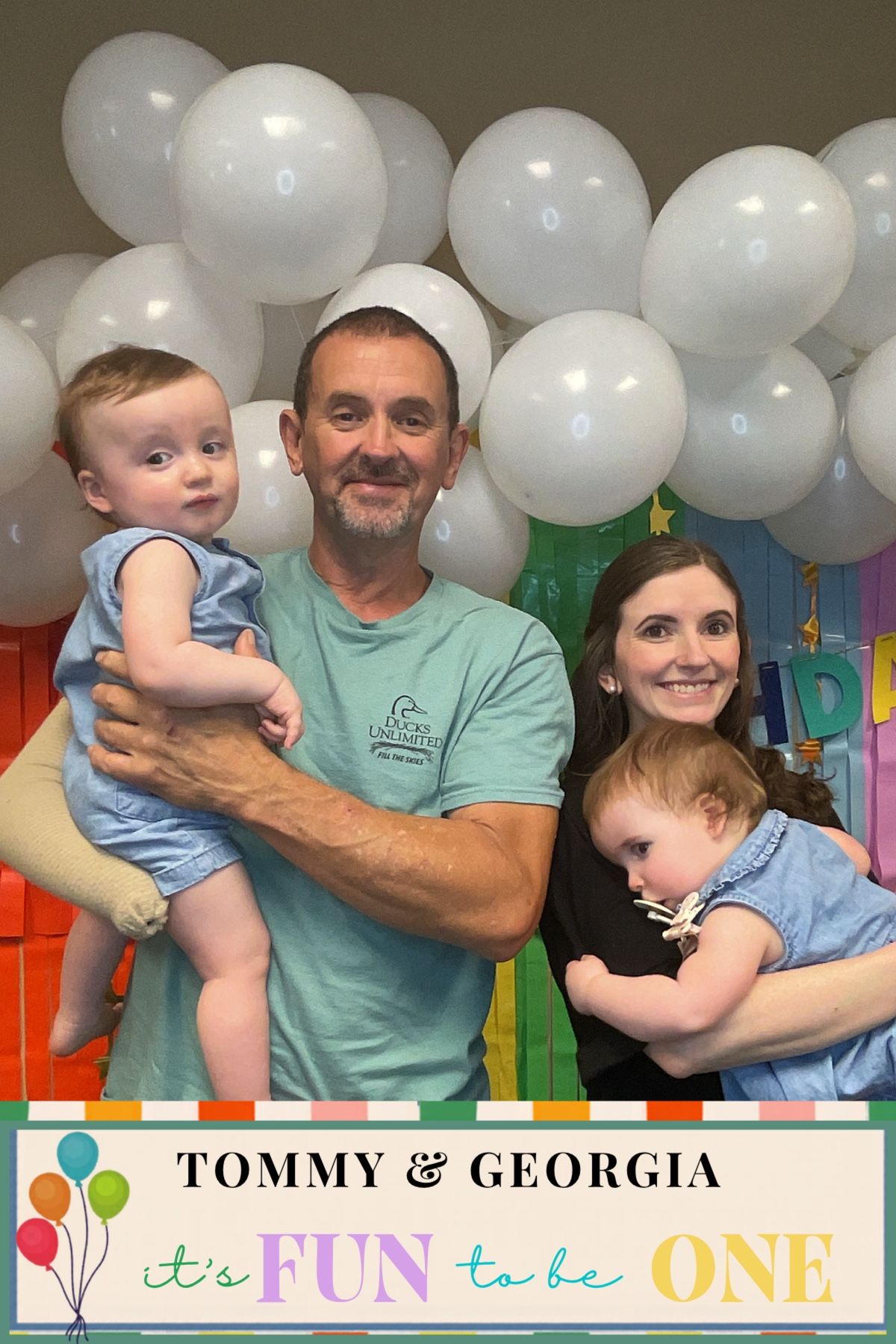 Family of four posing with white balloons at Tommy and Georgia's first birthday party celebration.