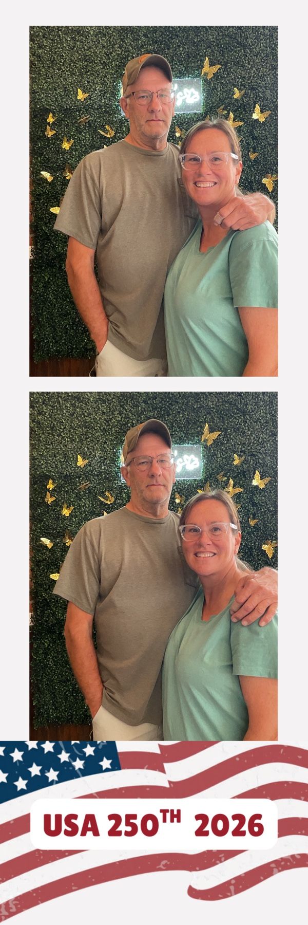 Couple posing at a USA 250th 2026 photo booth with a green hedge wall and gold butterfly backdrop.