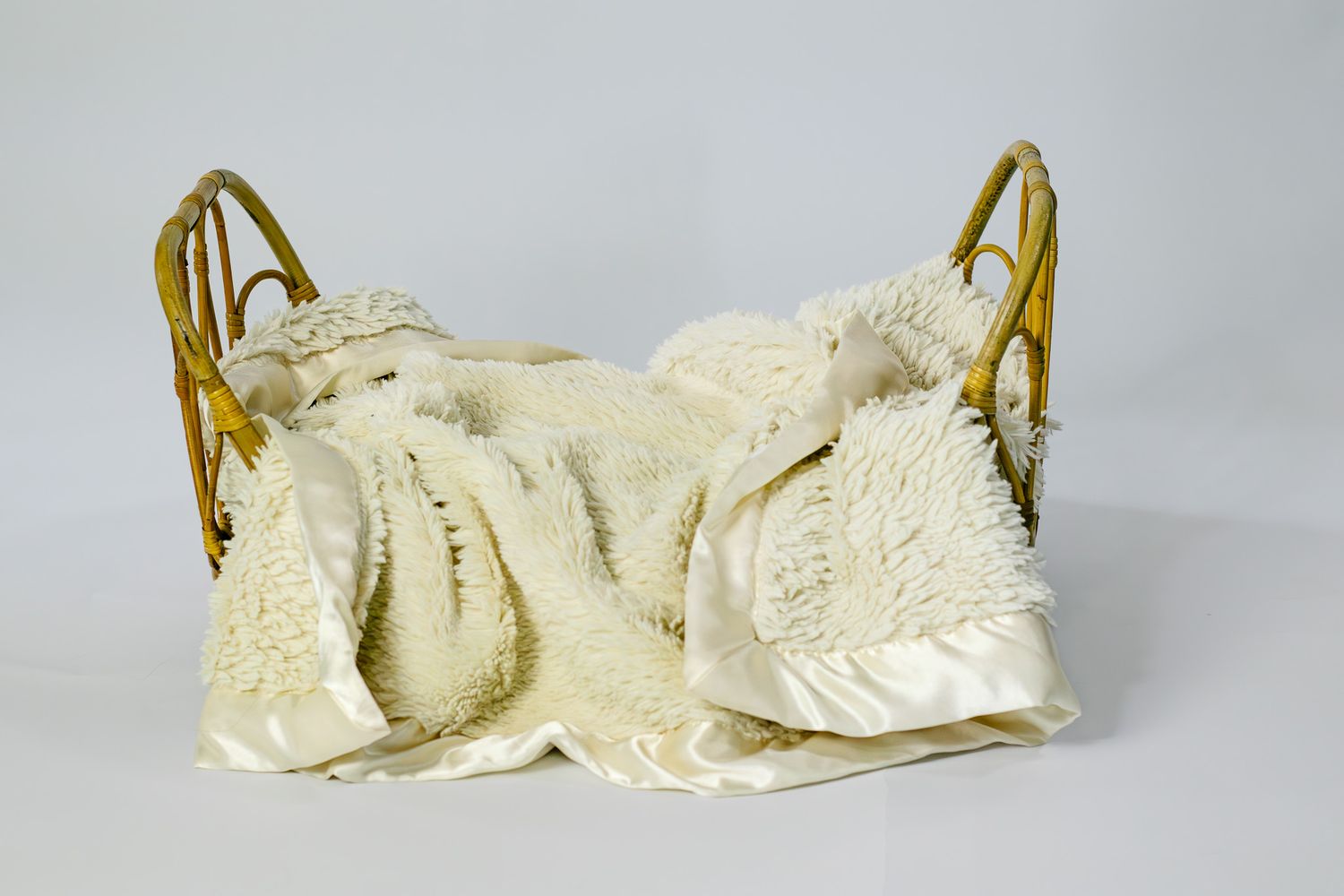 Gold metal doll bed with cream white fluffy blanket and satin trim, perfect for newborn photography props.