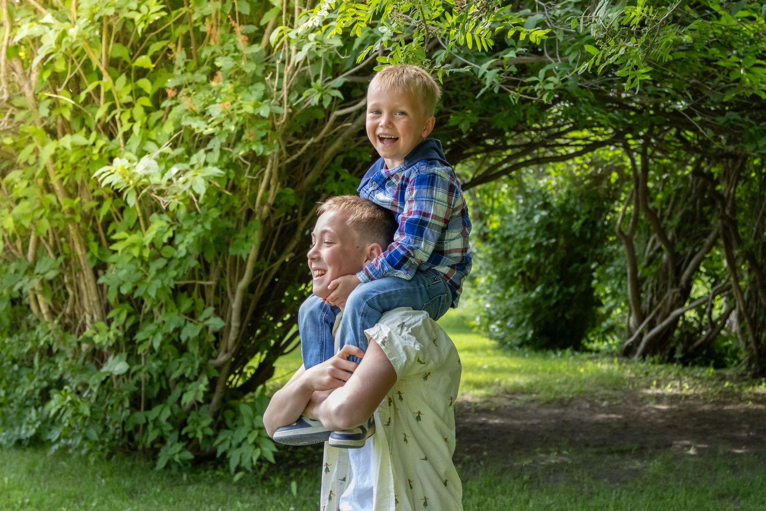 Family enjoys quality time together on a swing set in a lush backyard garden on a sunny afternoon.