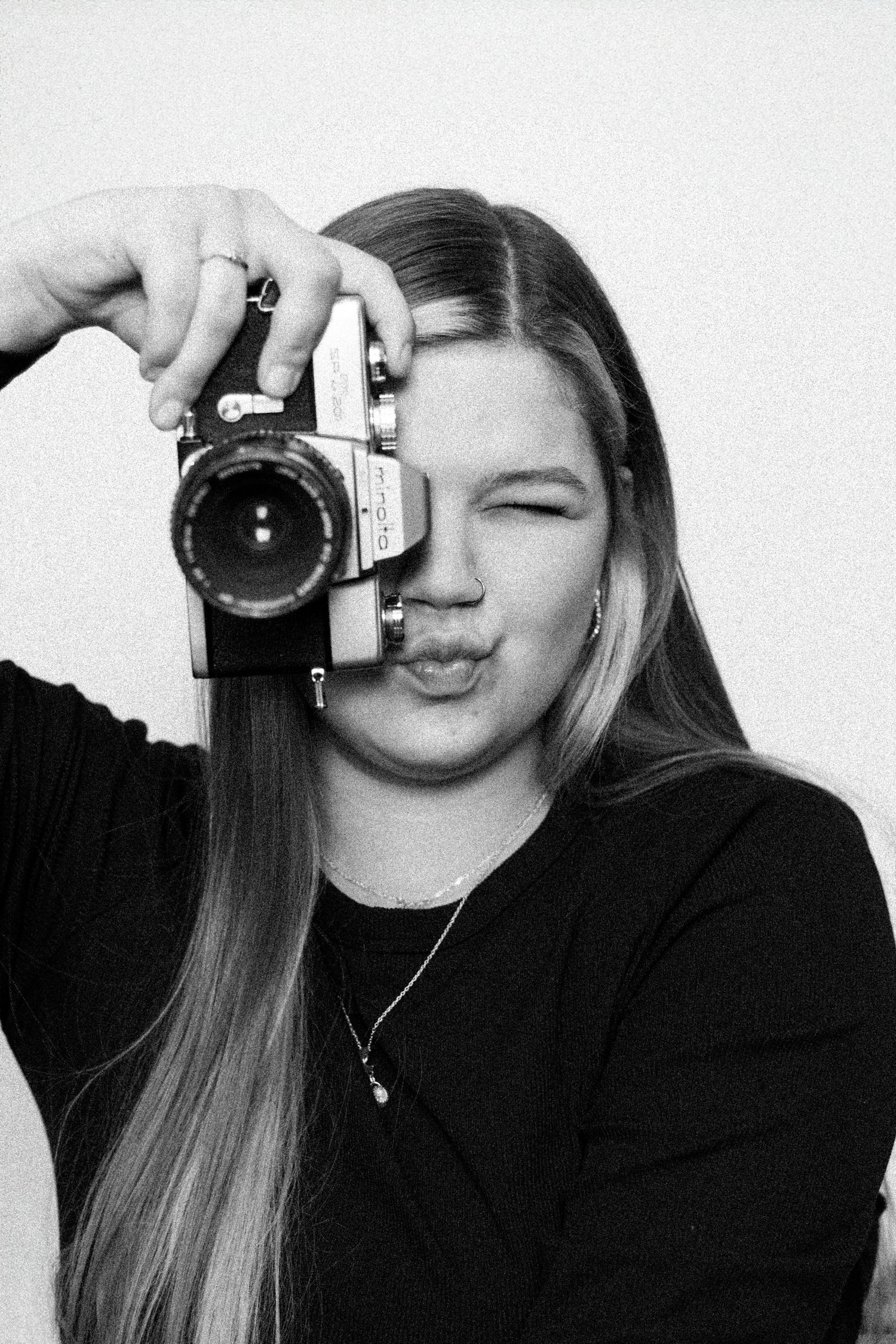 Black and white photo series showing someone holding a camera and making playful expressions while taking selfies.